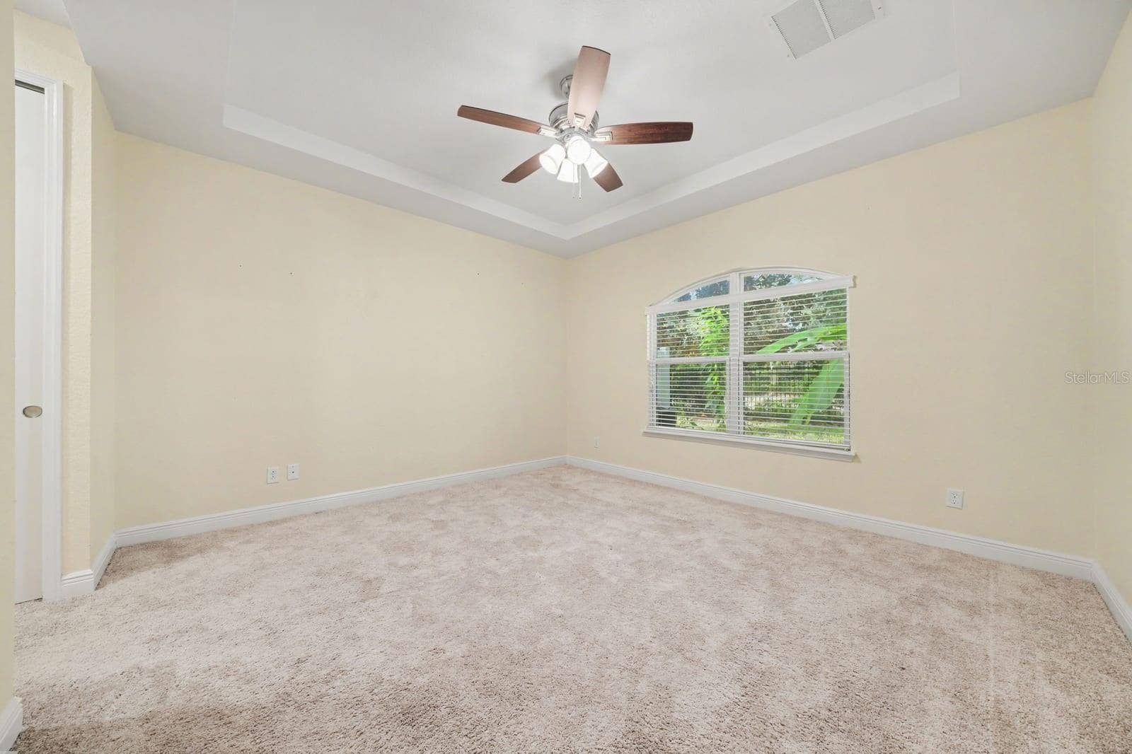 Spacious Bedroom with Ceiling Fan and Large Window