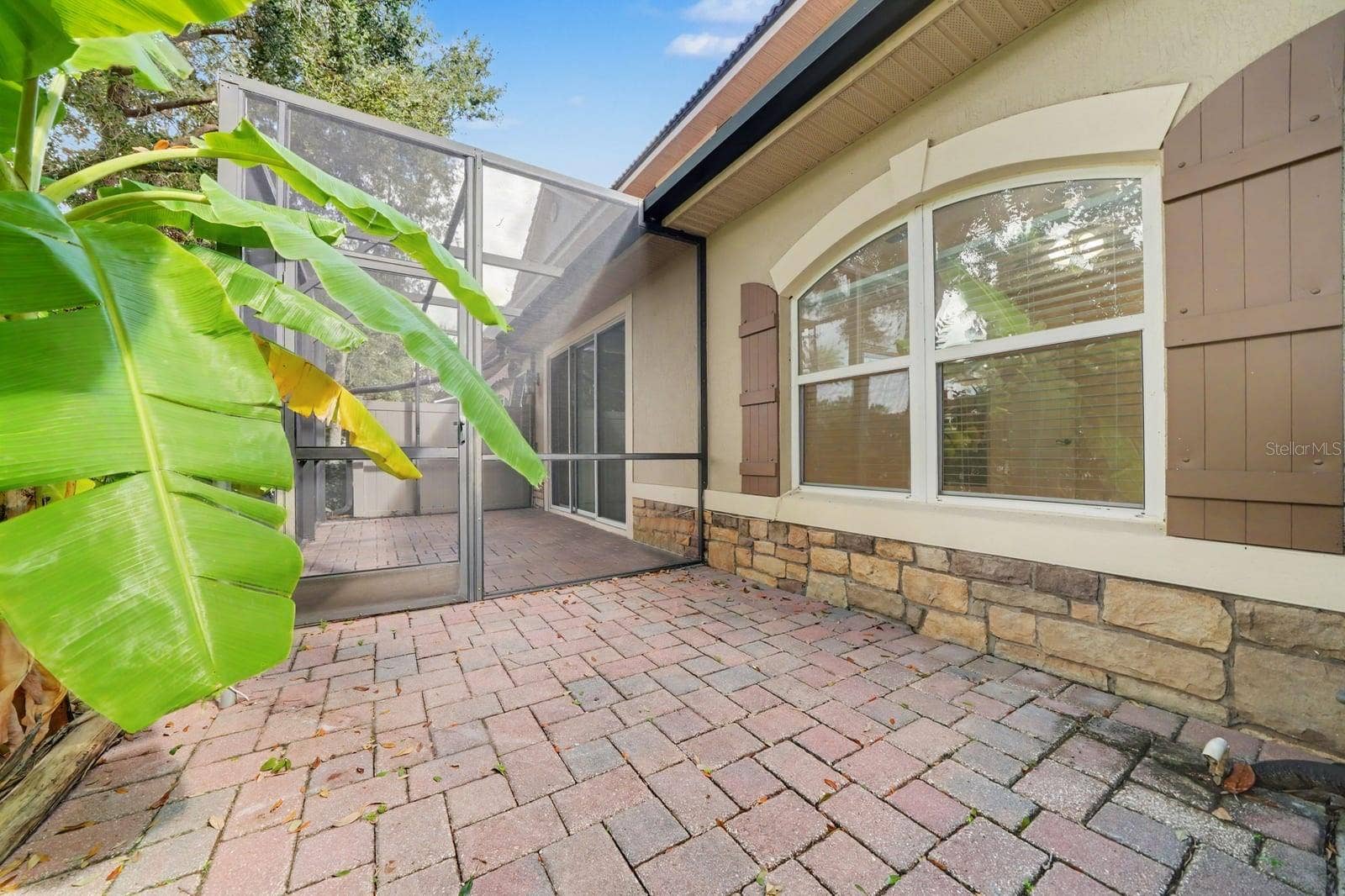 Screened Patio With Brick Pavers And Mature Landscaping