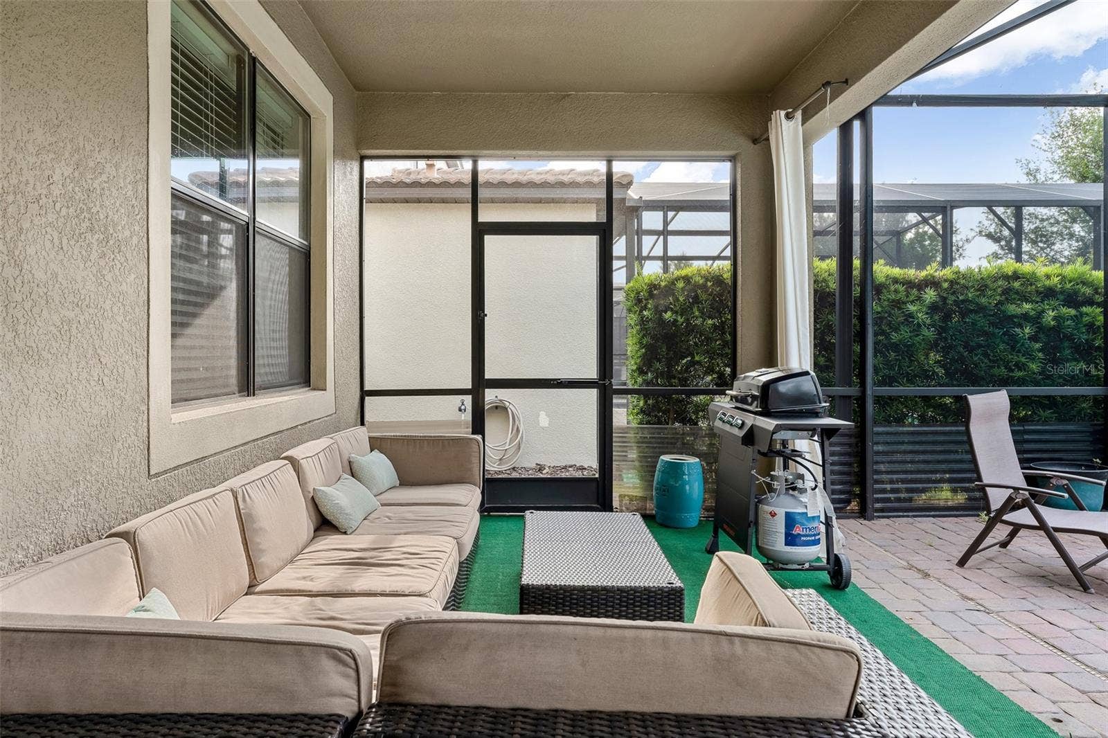 Covered Lanai with Comfortable Outdoor Seating and Direct Access to the Pool