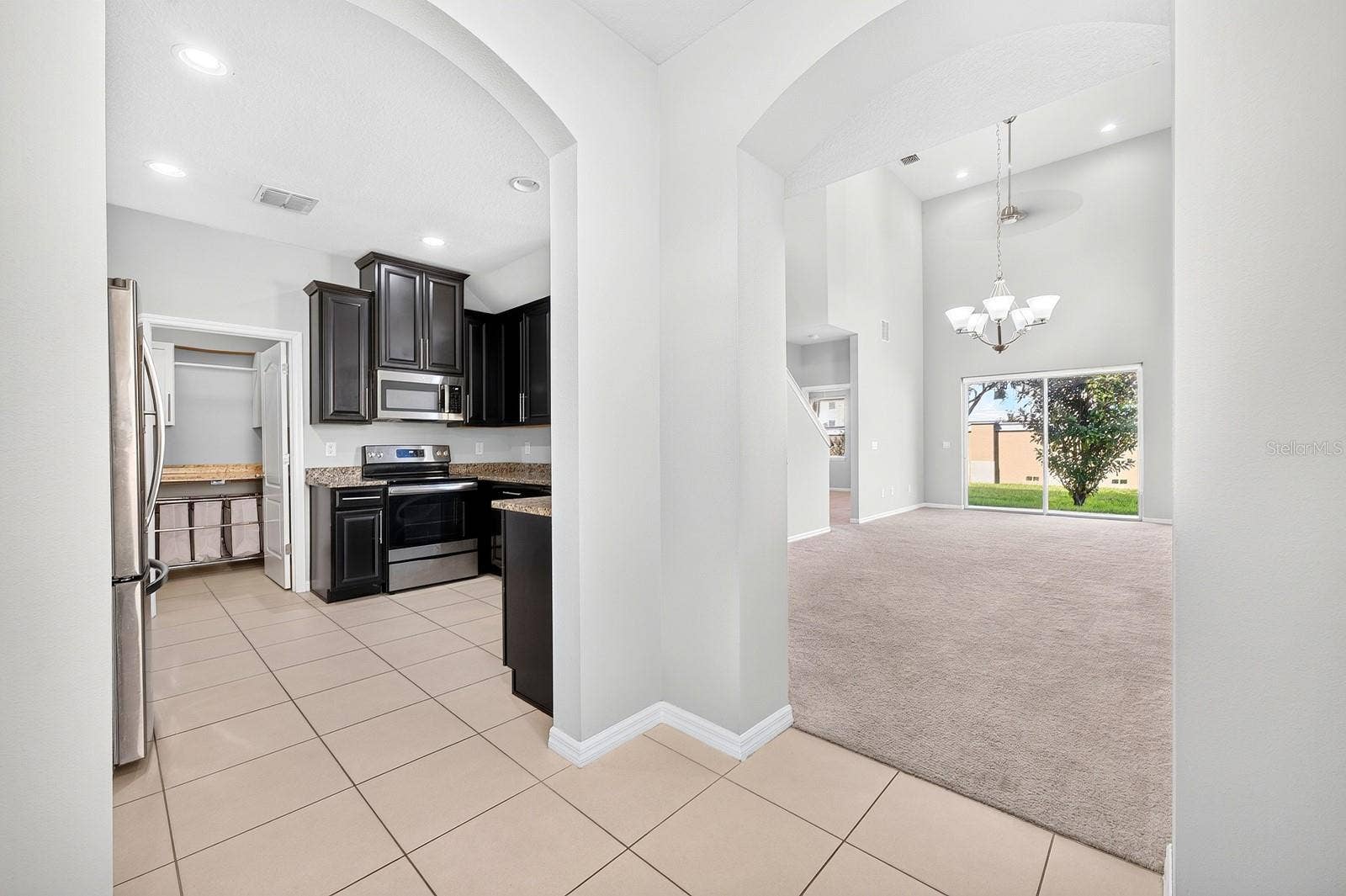 2128 LENNOX DALE LANE, Brandon, FL 33510 Elegant ARCHED DOORWAYS lead to the Kitchen and the OPEN LIVING and DINING AREA, creating a lovely sense of flow between the main gathering spaces.