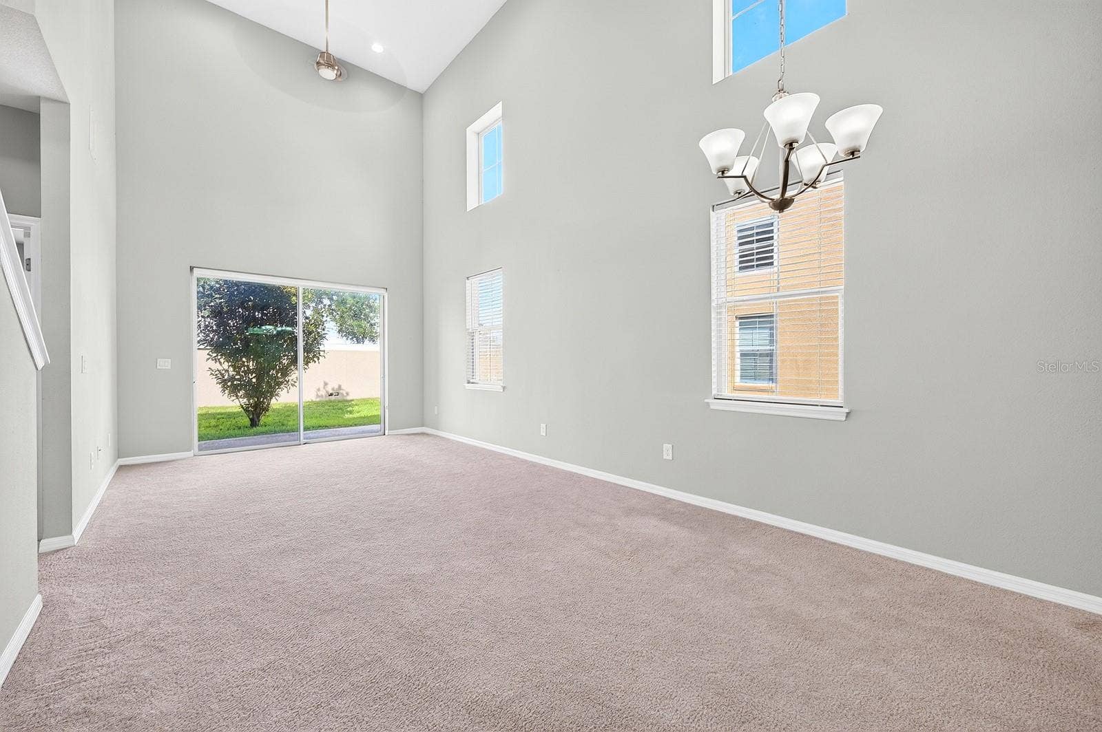 2128 LENNOX DALE LANE, Brandon, FL 33510 Two-story windows fill the Living/Dining Room with NATURAL LIGHT, while sliding glass doors extend the living space outdoors.