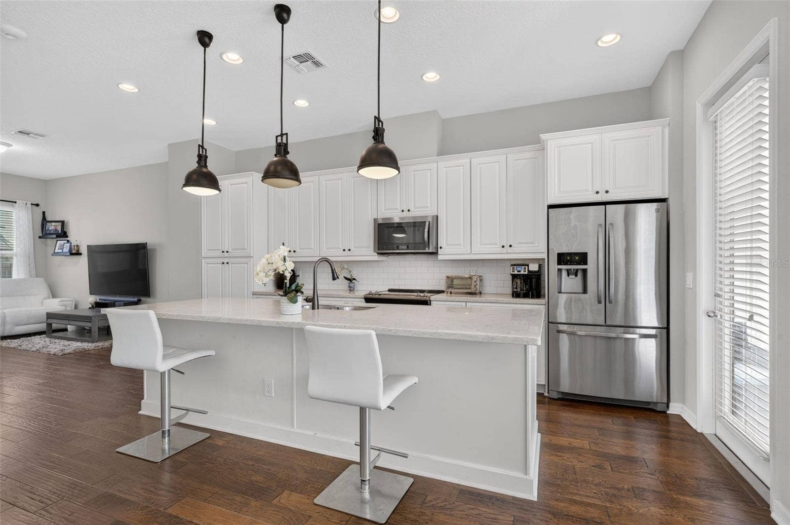 716 GRADO POINT, Oviedo, FL 32765 The Luxurious kitchen features solid stone counters, 42-inch cabinetry, laminate wood flooring and stainless appliances.