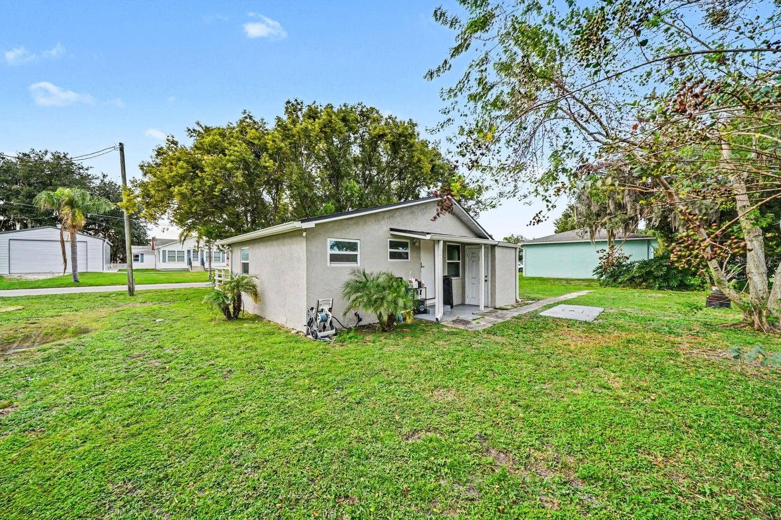 1611 SALMON STREET, St Cloud, FL 34771 Peaceful setting with updated exterior and spacious lawn surrounded by mature trees