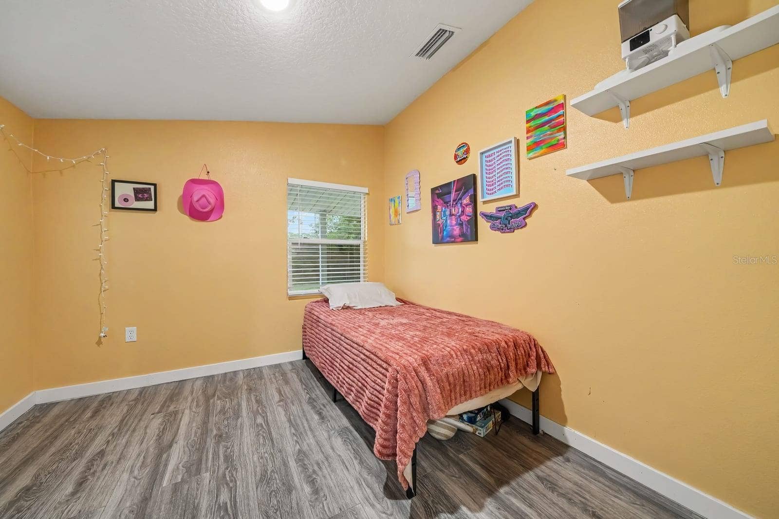 1611 SALMON STREET, St Cloud, FL 34771 Bright Bedroom with Yellow Walls, Wood Flooring & Large Window