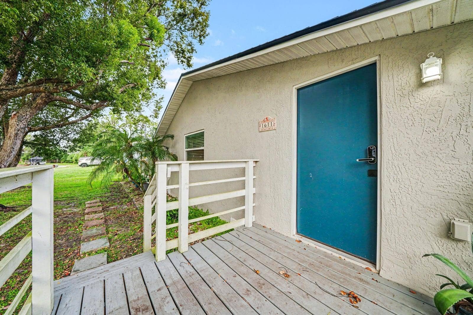 1611 SALMON STREET, St Cloud, FL 34771 Covered Deck Entry with Teal Door & White Rail Accents