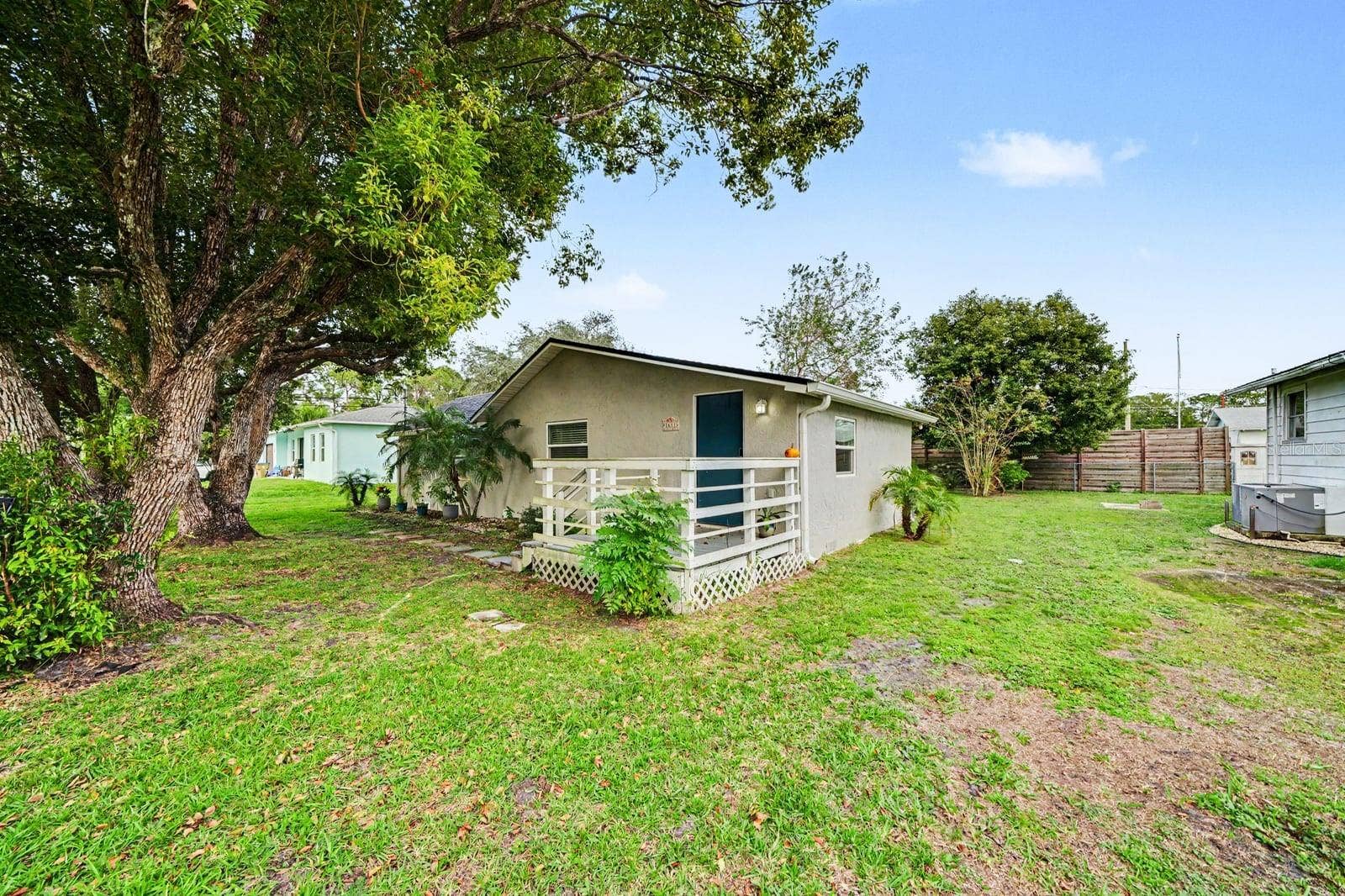 1611 SALMON STREET, St Cloud, FL 34771 Home Exterior with Mature Trees, Landscaping & Entry Deck