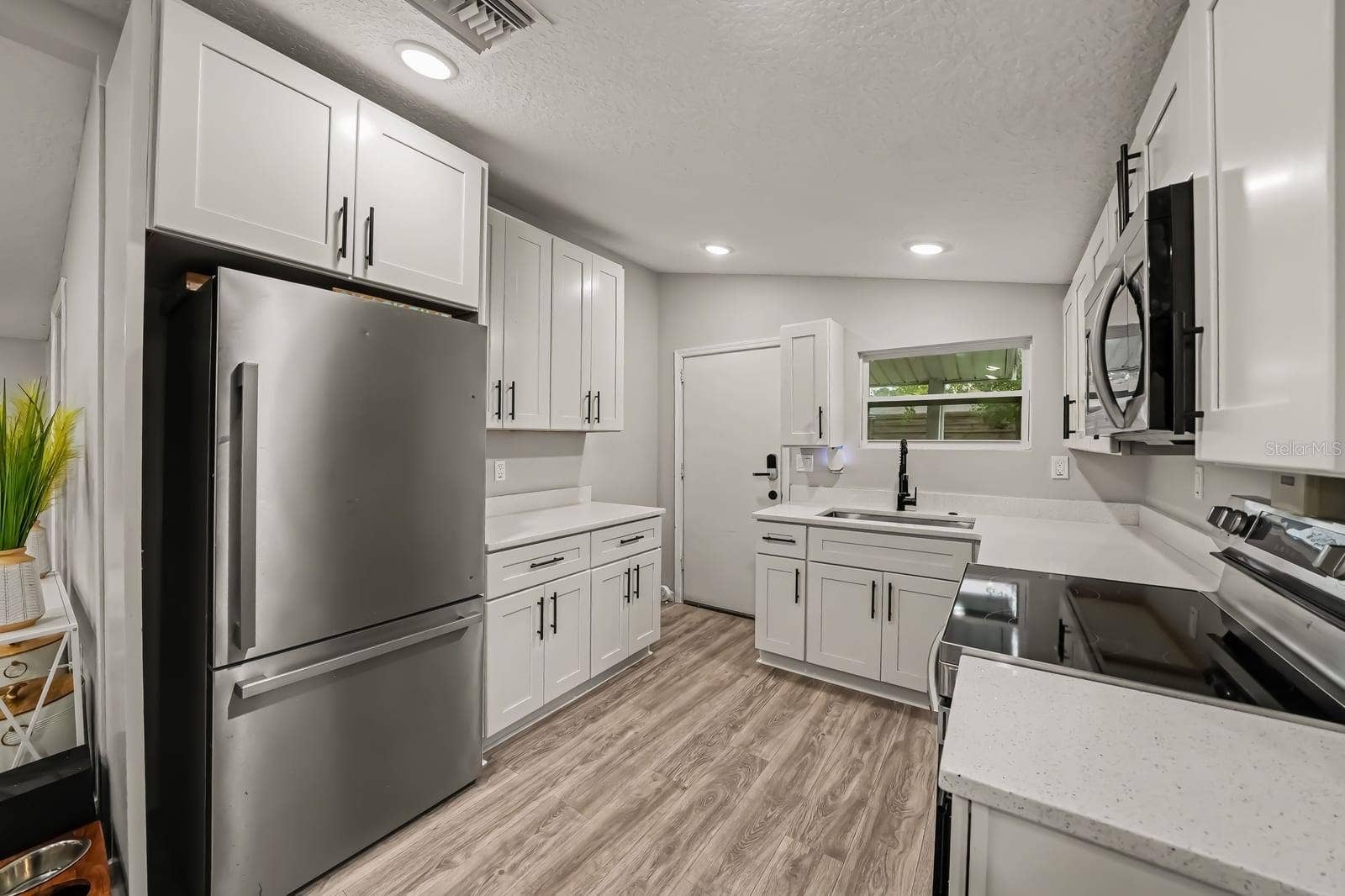 1611 SALMON STREET, St Cloud, FL 34771 Spacious Kitchen with Stainless Steel Appliances and White Cabinetry