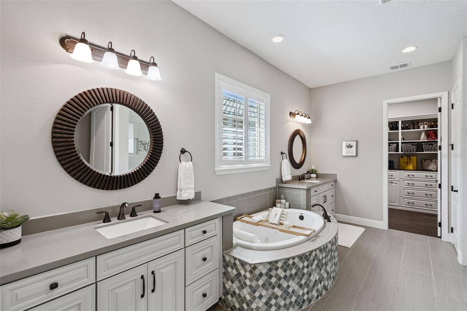 Owners bathroom with dual vanities, a soaking tub, spacious walk-in shower