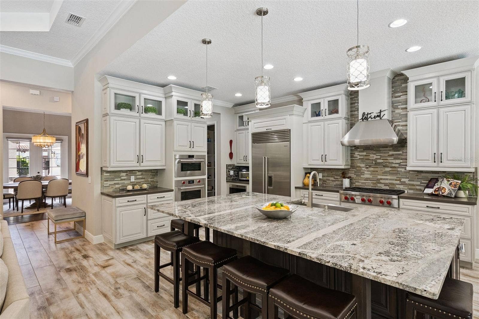 Gourmet kitchen featuring custom cabinetry, Sub-Zero Wolf appliance packages and oversized granite island w/ seating for 6