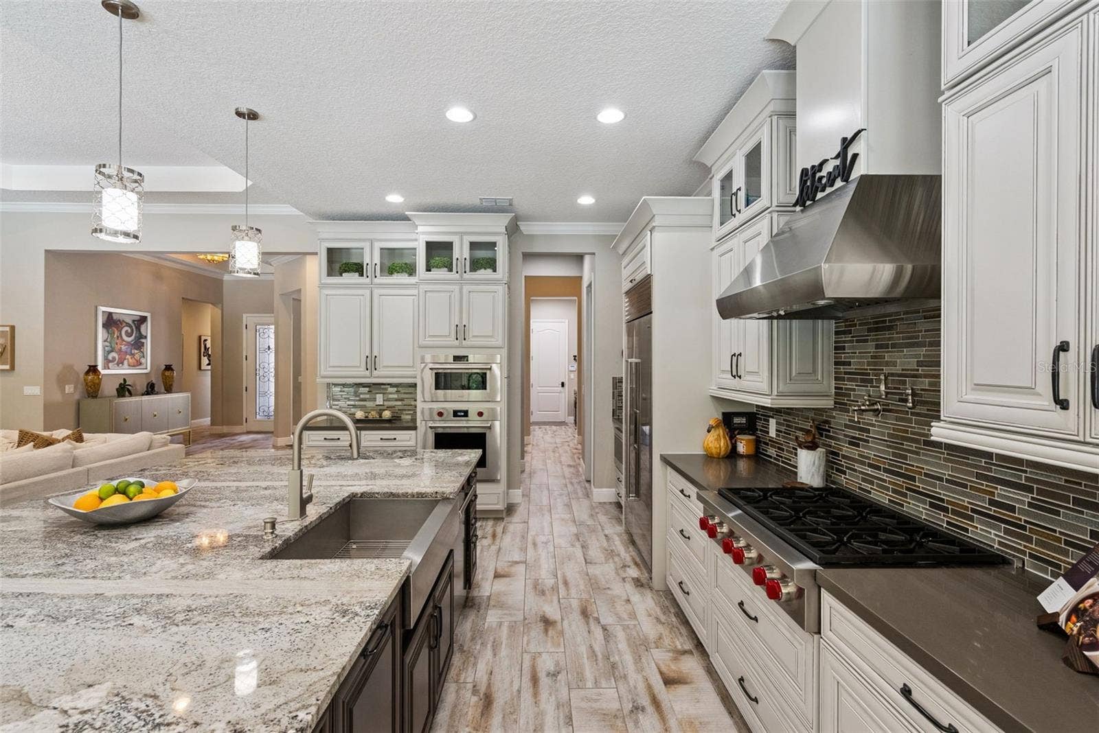 Gourmet kitchen featuring custom cabinetry, Sub-Zero Wolf appliance packages and oversized granite island w/ seating for 6