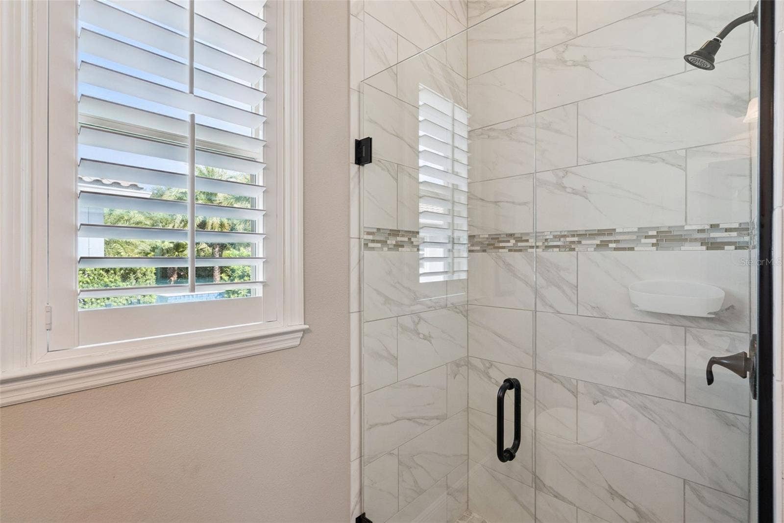Pool bathroom off kitchen near screened-in, covered lanai