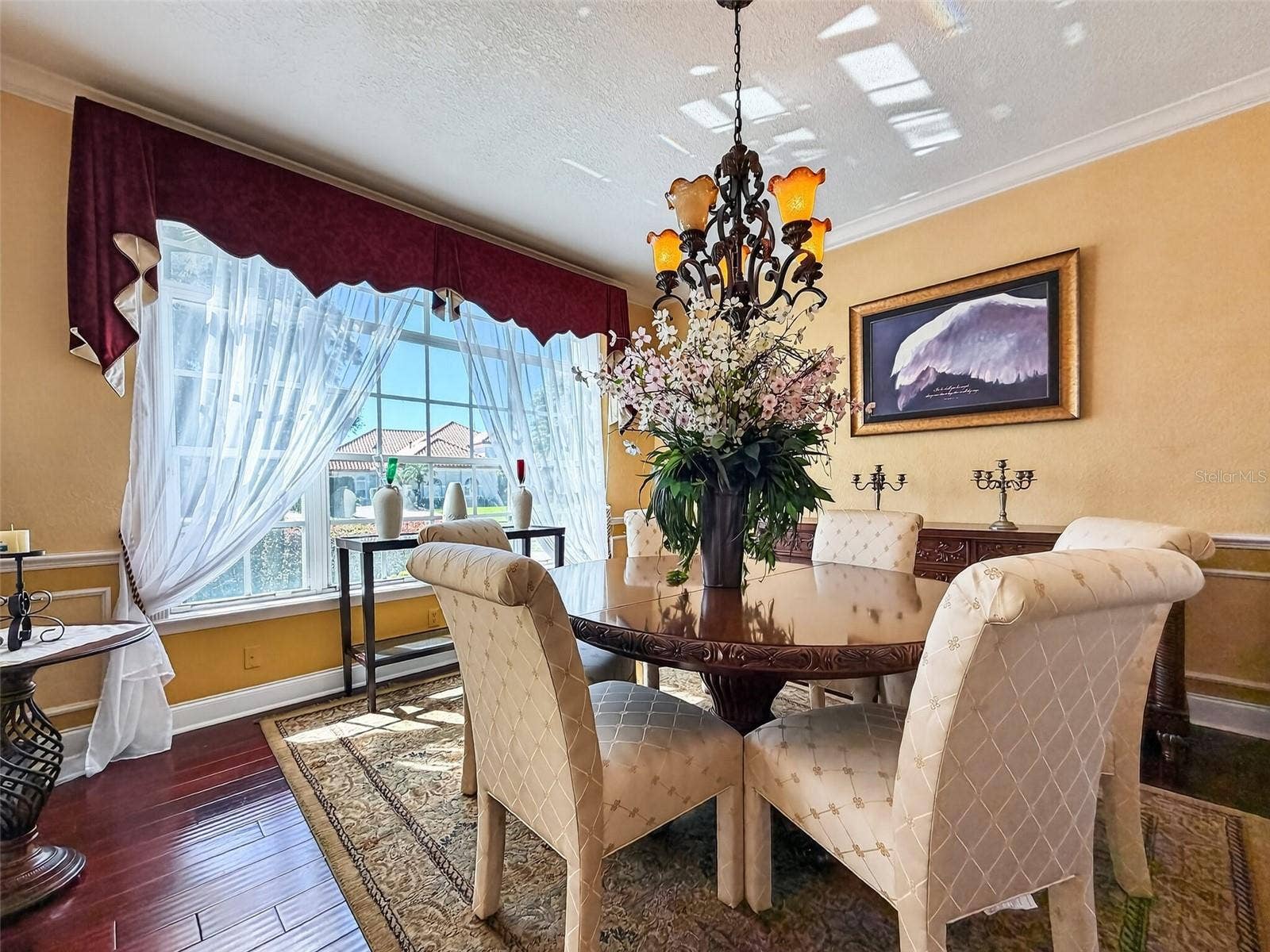 Formal dining room with wide-plank wood floors and wainscoting