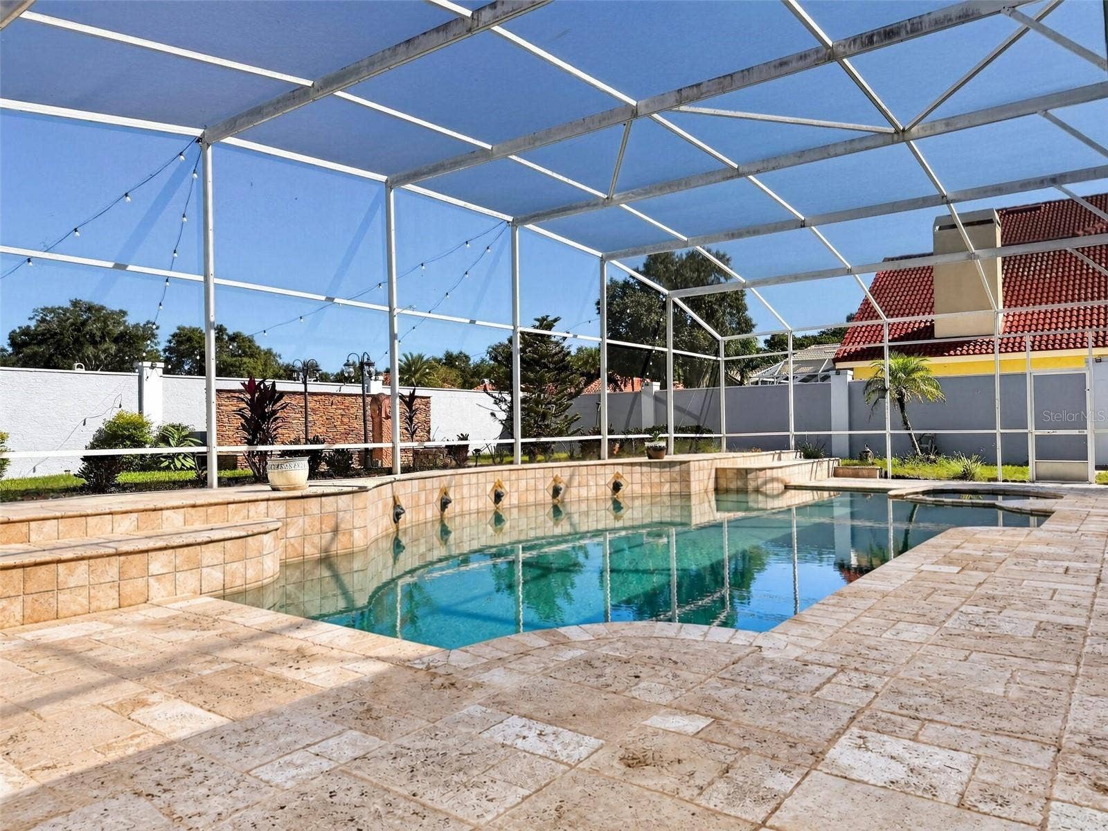 Pool with travertine deck and waterfall features