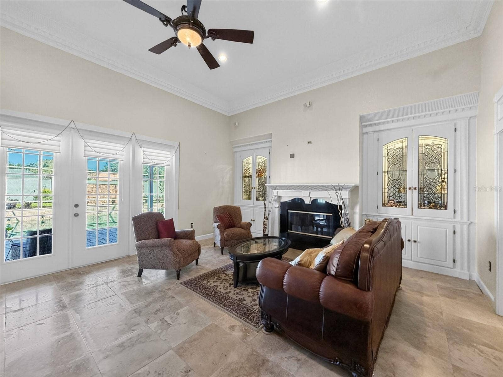 Living room with built-in glass cabinetry and surround sound
