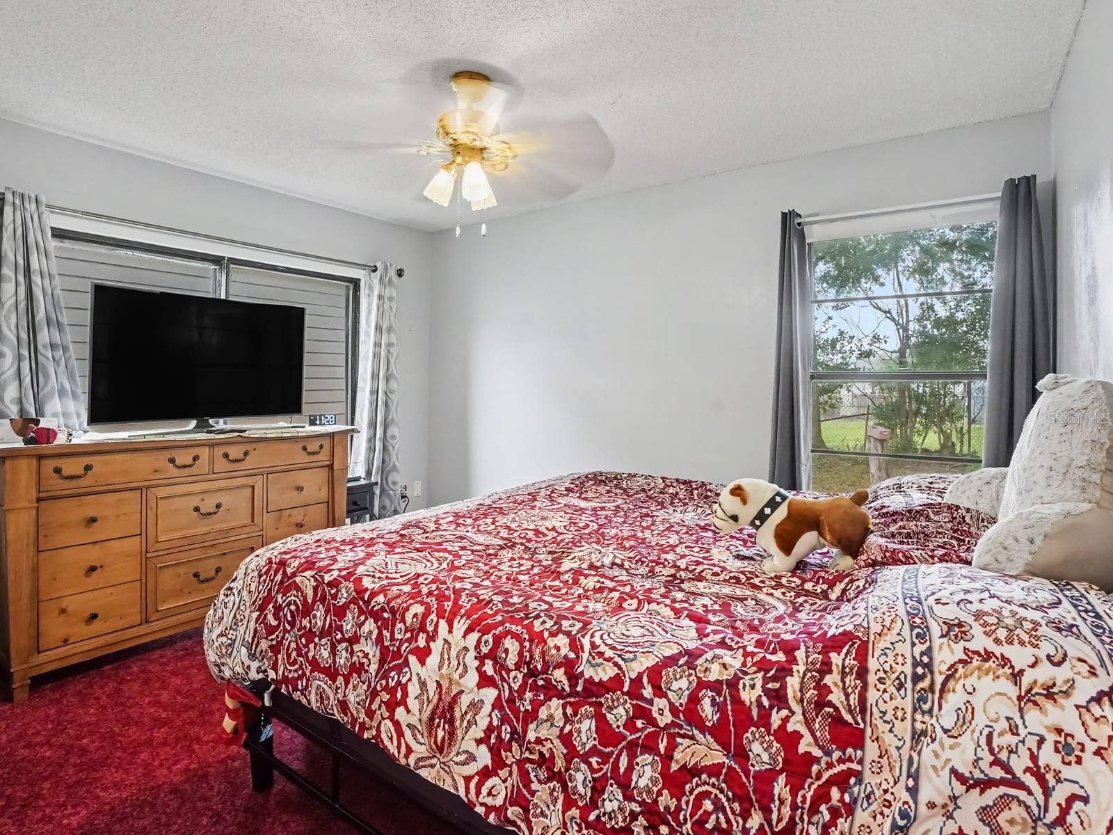 Comfortable Bedroom with Wood Dresser, TV, and Outdoor Views
