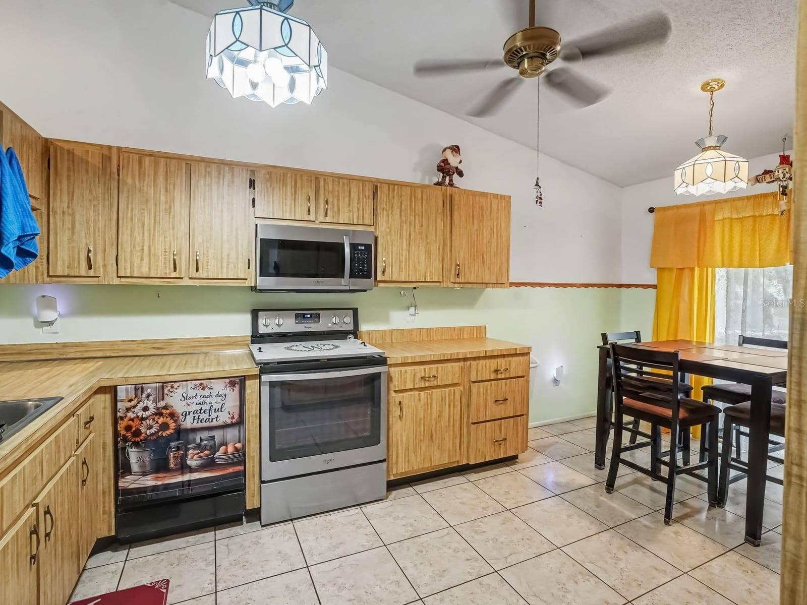 Bright Kitchen with Wood Cabinetry, Dining Area & Yellow Accents