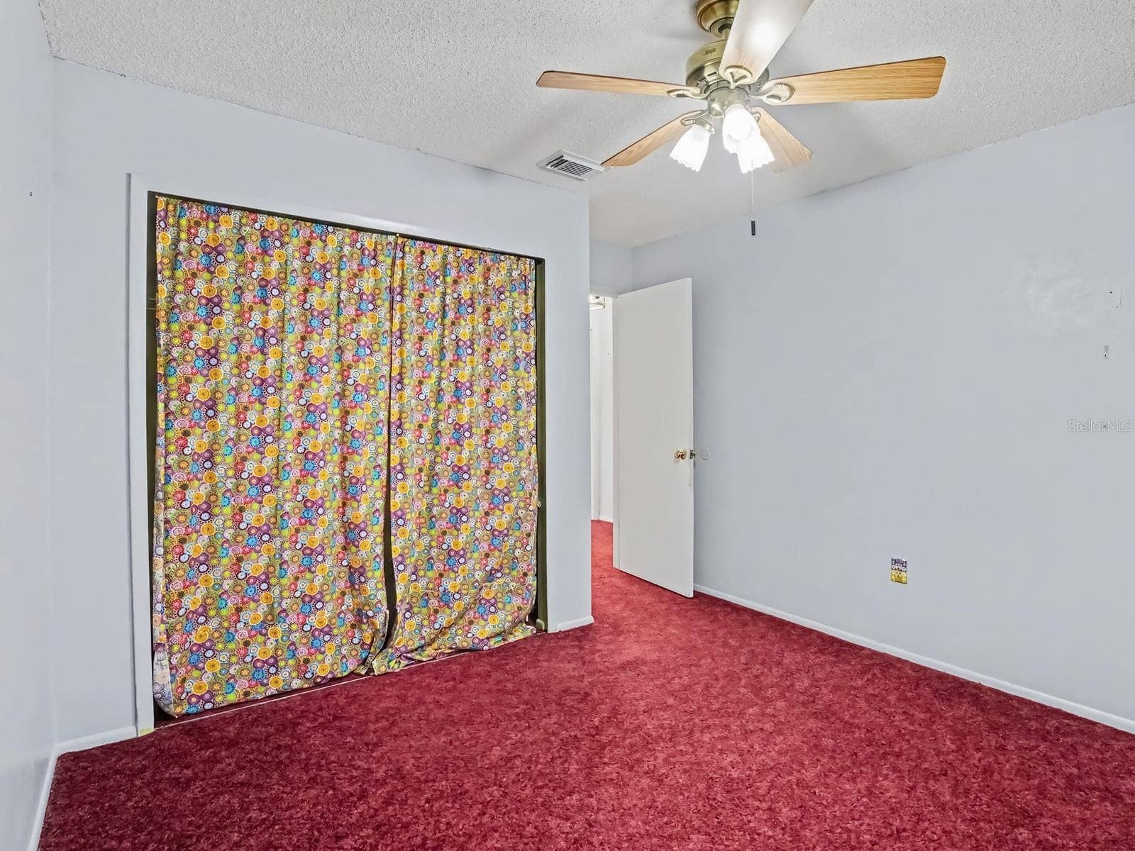 Generous Bedroom with Closet and Red Carpet Flooring