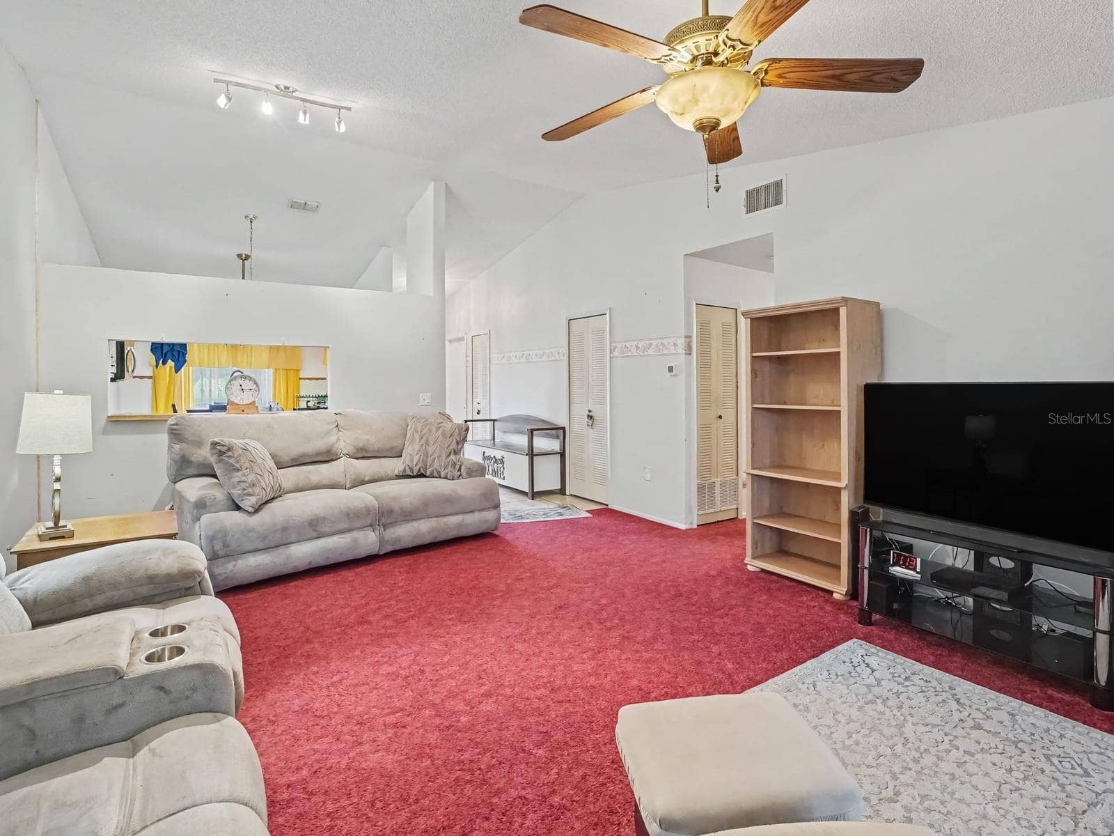 Bright great room with vaulted ceiling, ceiling fan & entertainment space