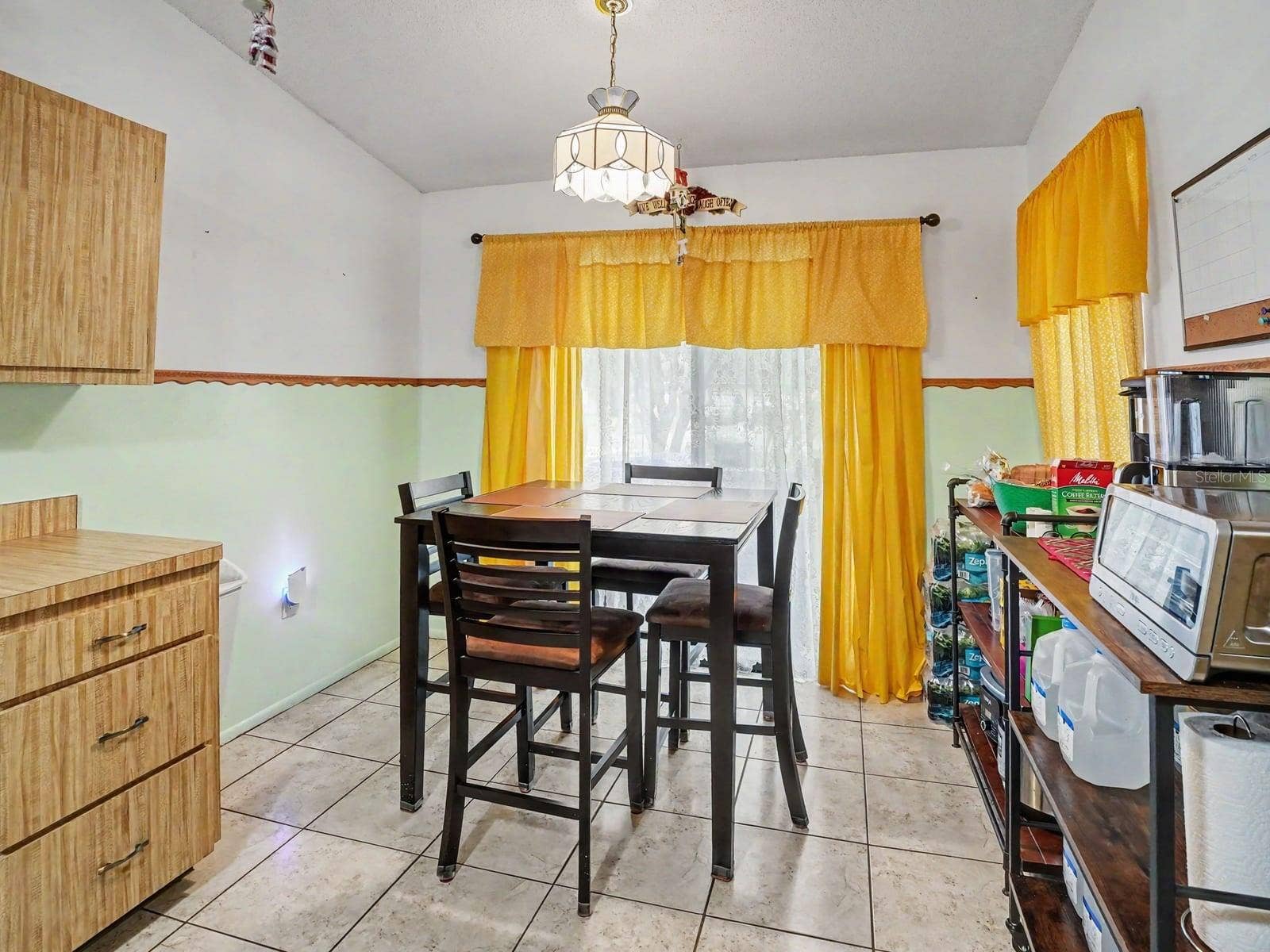 Kitchen-dining area with table seating & yellow window treatments