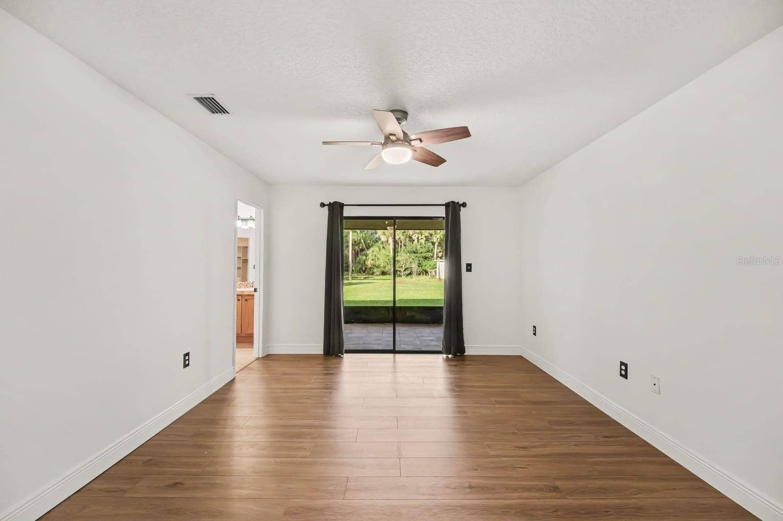 5560 BOB WHITE TRAIL, Mims, FL 32754 Bright Family Room with Sliding Glass Doors Opening to Backyard and Lawn