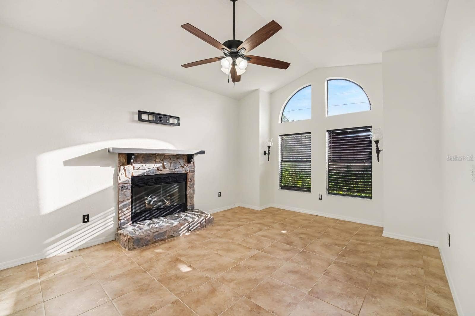 5560 BOB WHITE TRAIL, Mims, FL 32754 Curved fireplace mantel, large windows, and open floor plan design