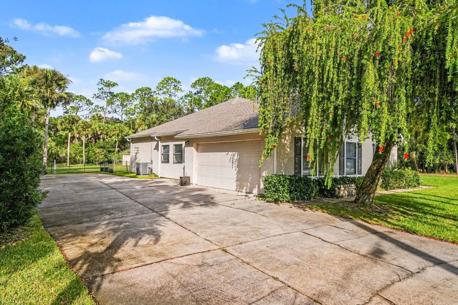 5560 BOB WHITE TRAIL, Mims, FL 32754 Front elevation features attached garage, mature trees, and welcoming approach