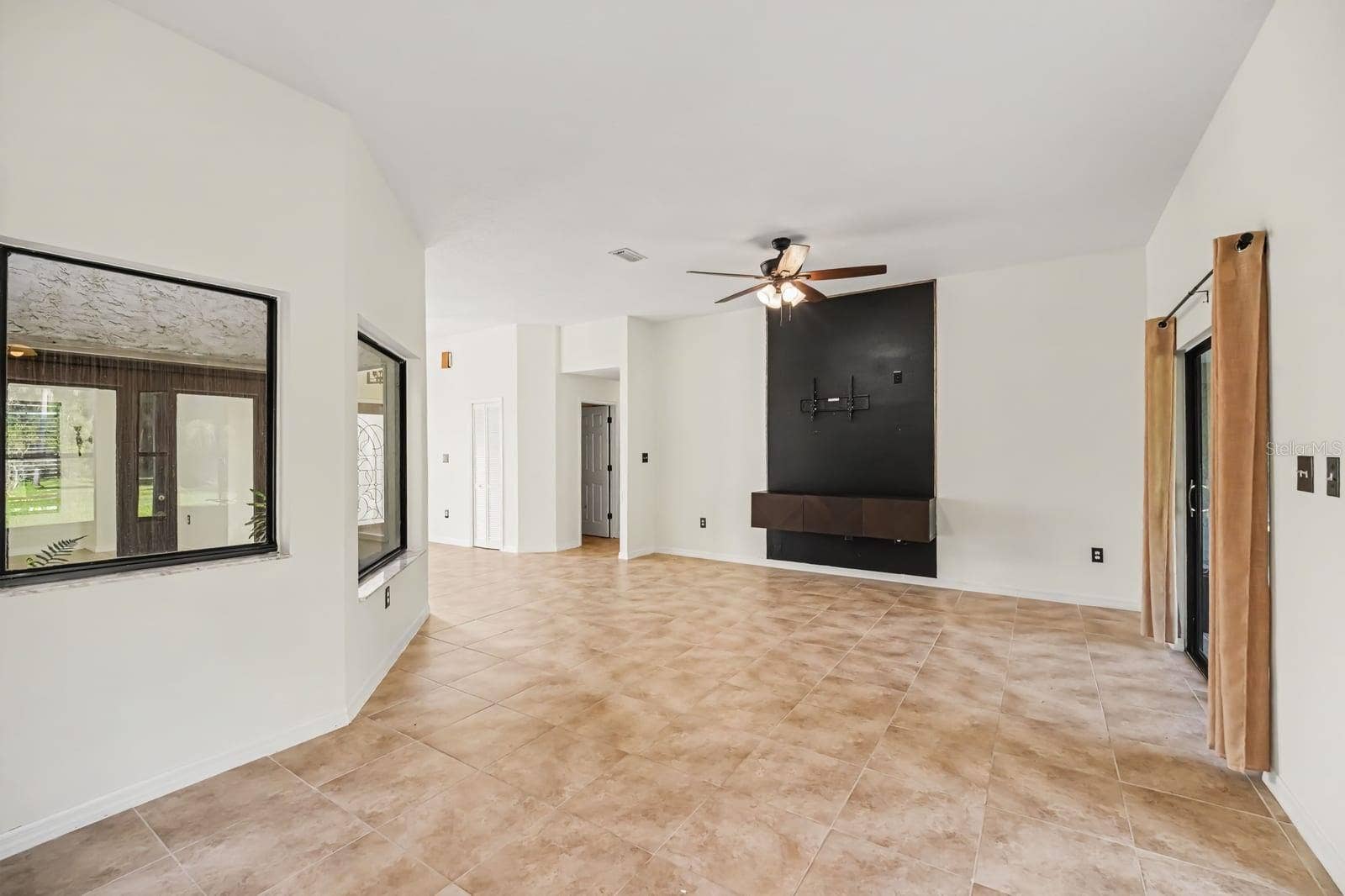 5560 BOB WHITE TRAIL, Mims, FL 32754 Expansive great room with modern kitchen island and outdoor views