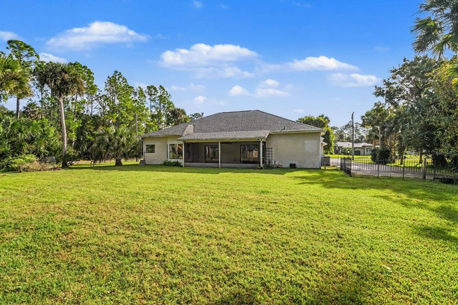 5560 BOB WHITE TRAIL, Mims, FL 32754 Expansive rear yard with mature landscaping and covered patio overlooking lush grounds