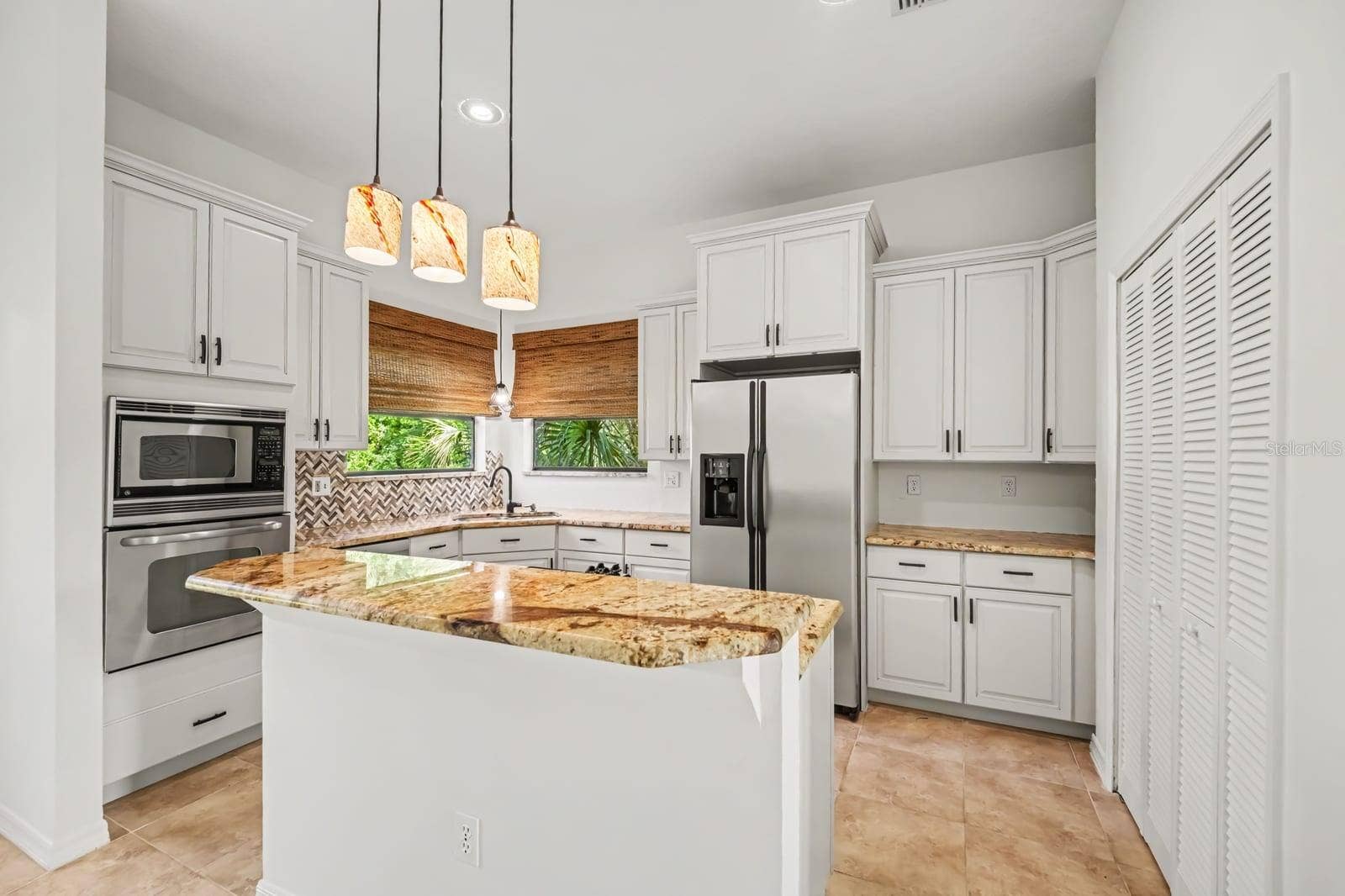 5560 BOB WHITE TRAIL, Mims, FL 32754 Chef's Kitchen Featuring Granite Island, White Cabinetry & Integrated Appliances