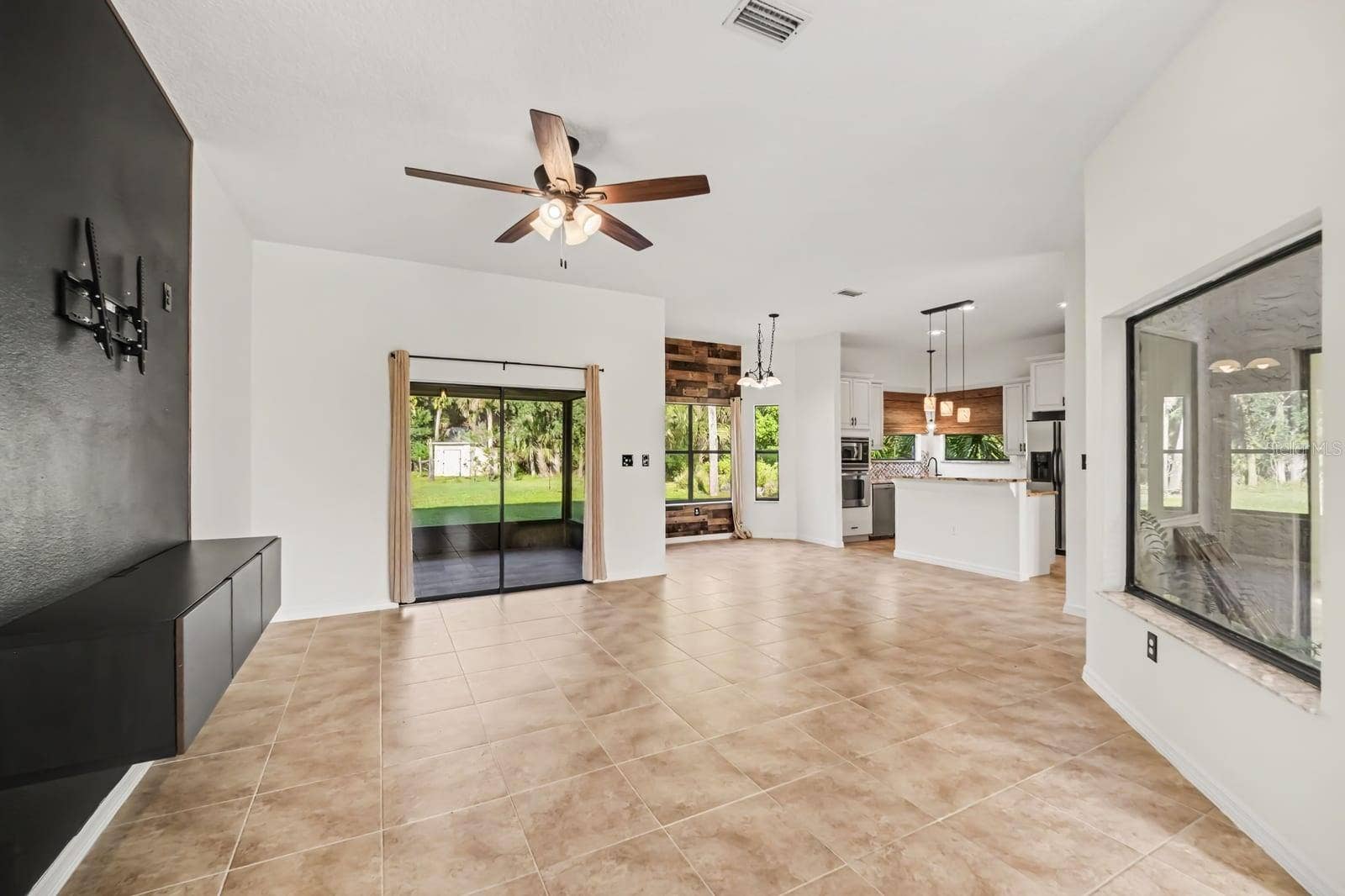 5560 BOB WHITE TRAIL, Mims, FL 32754 Open-concept living space connects to kitchen with sliding glass doors