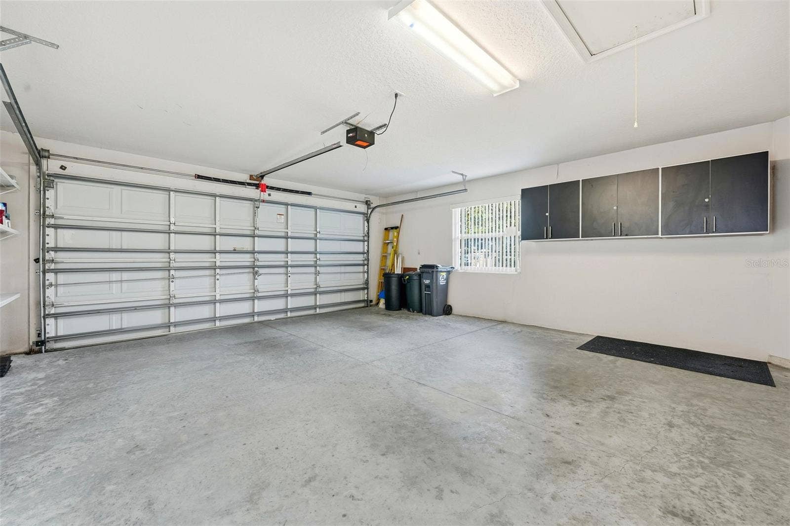 2311 N ANDREA POINT, Lecanto, FL 34461 2-car garage with extra storage cabinets, shelving and pull down stairs for attic access