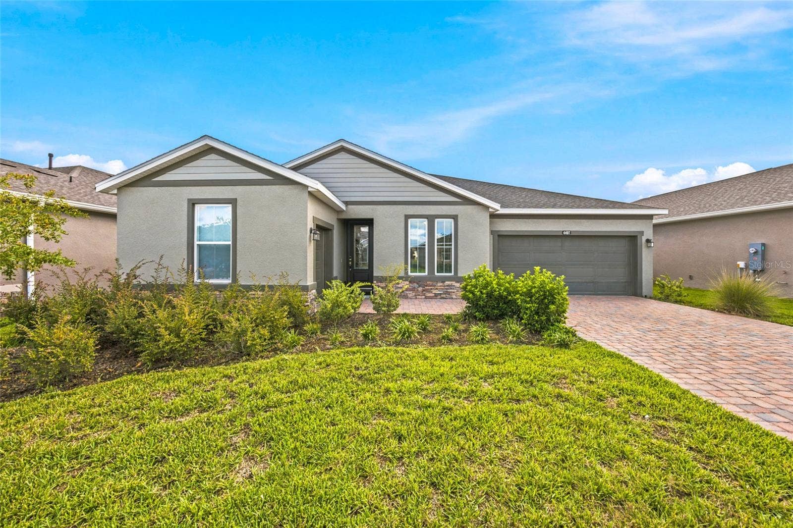 Welcoming front elevation with attractive landscaping, stone accents and a two-car garage.
