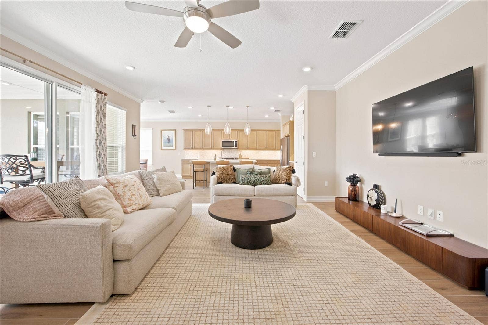 Spacious living room offering an open view into the kitchen and access to the covered patio.