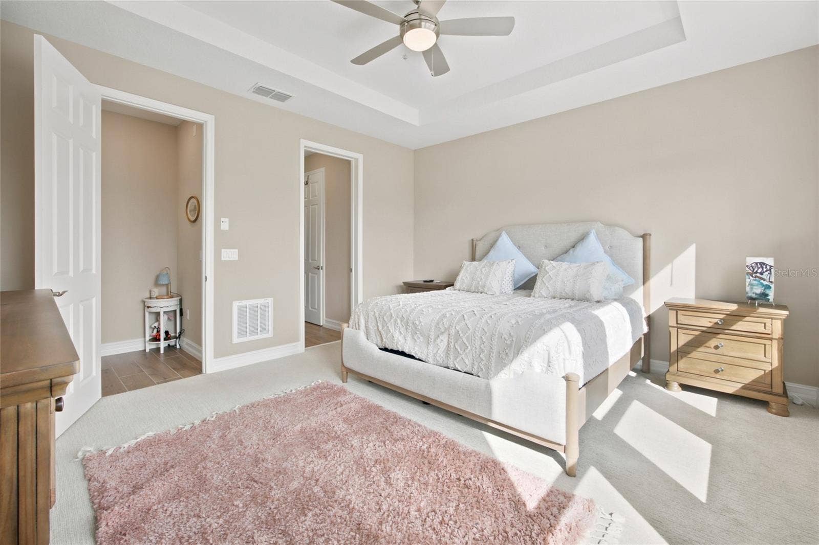 Primary bedroom from a second perspective, showing its spacious layout and adjoining entrances.