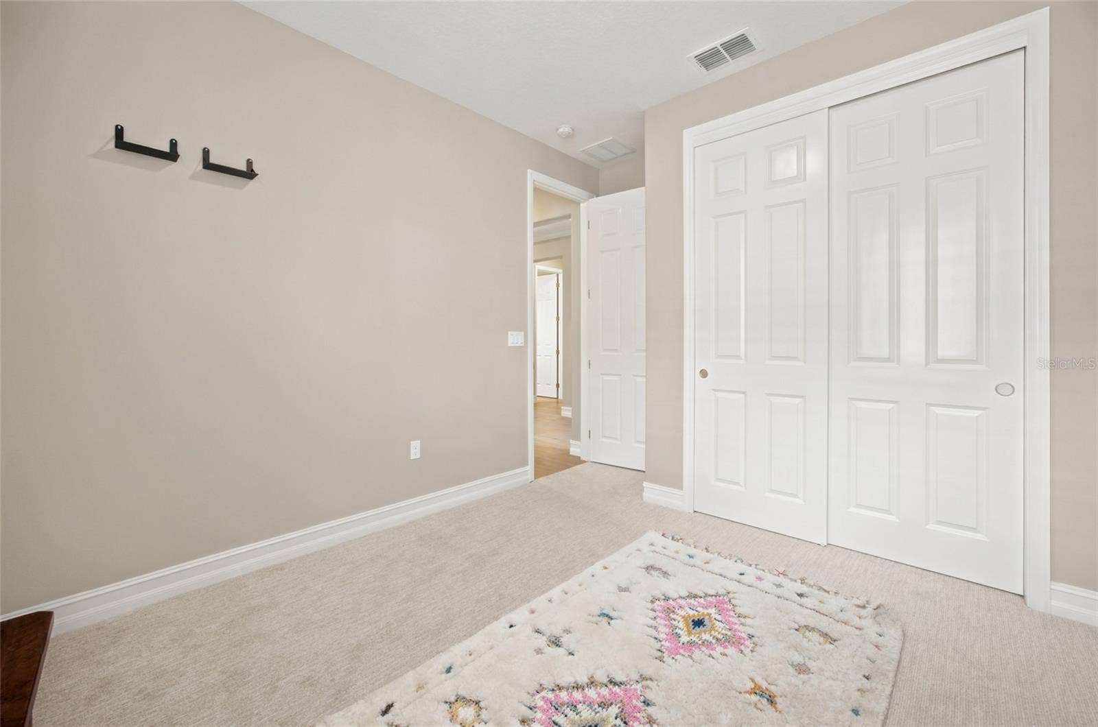 Additional view of the secondary bedroom showing its double-door closet.