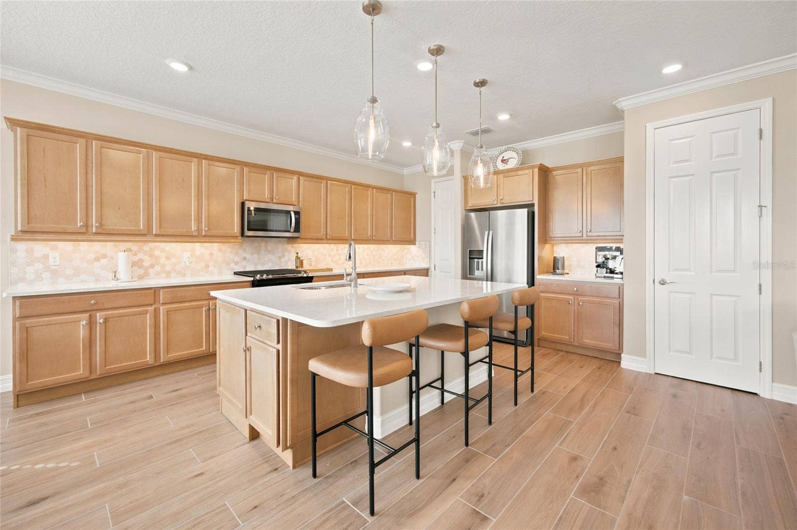 Beautifully appointed kitchen with expansive cabinetry, a central island and breakfast-bar seating.