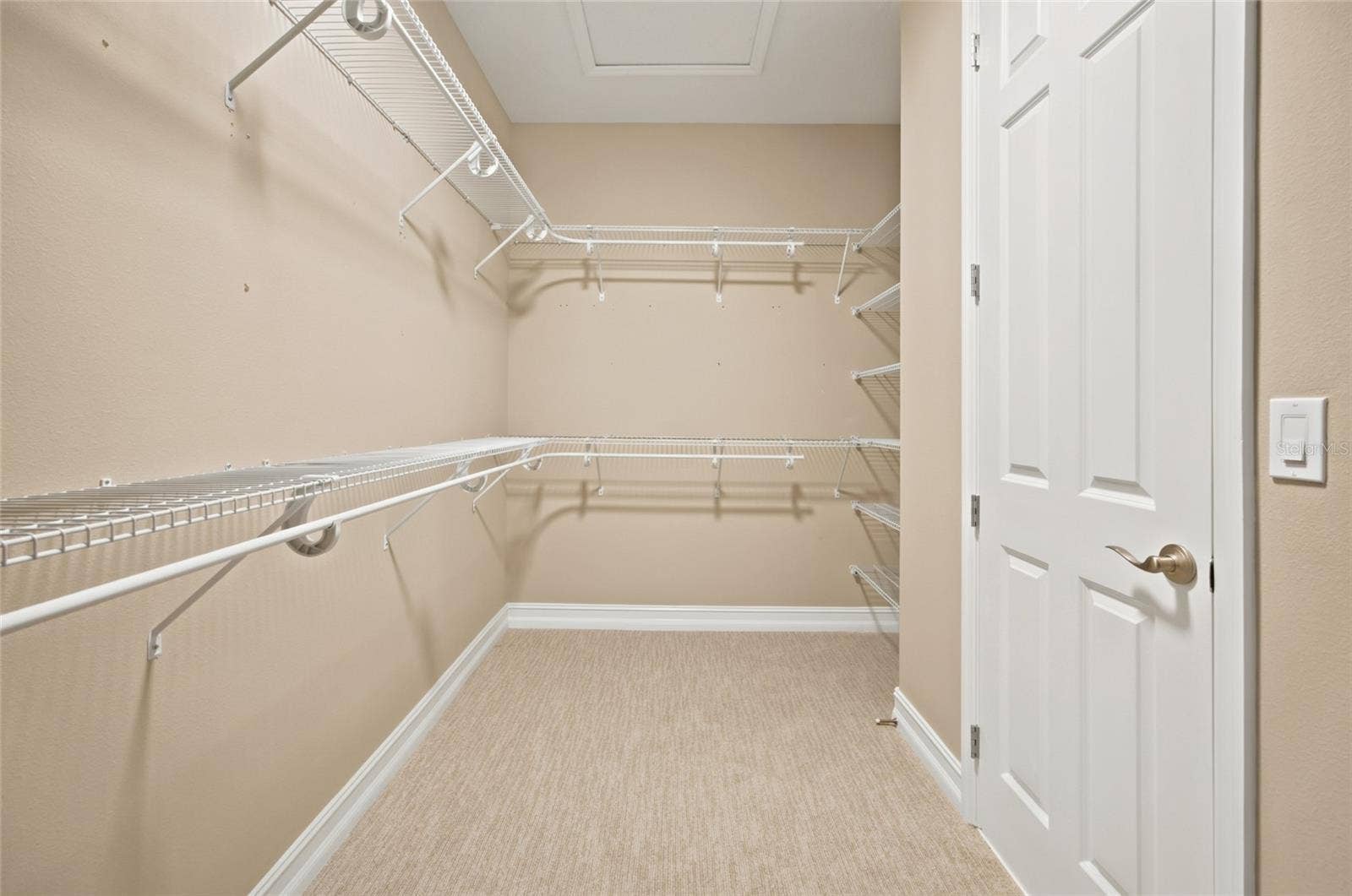 Generous walk-in closet with wraparound shelving and hanging space.