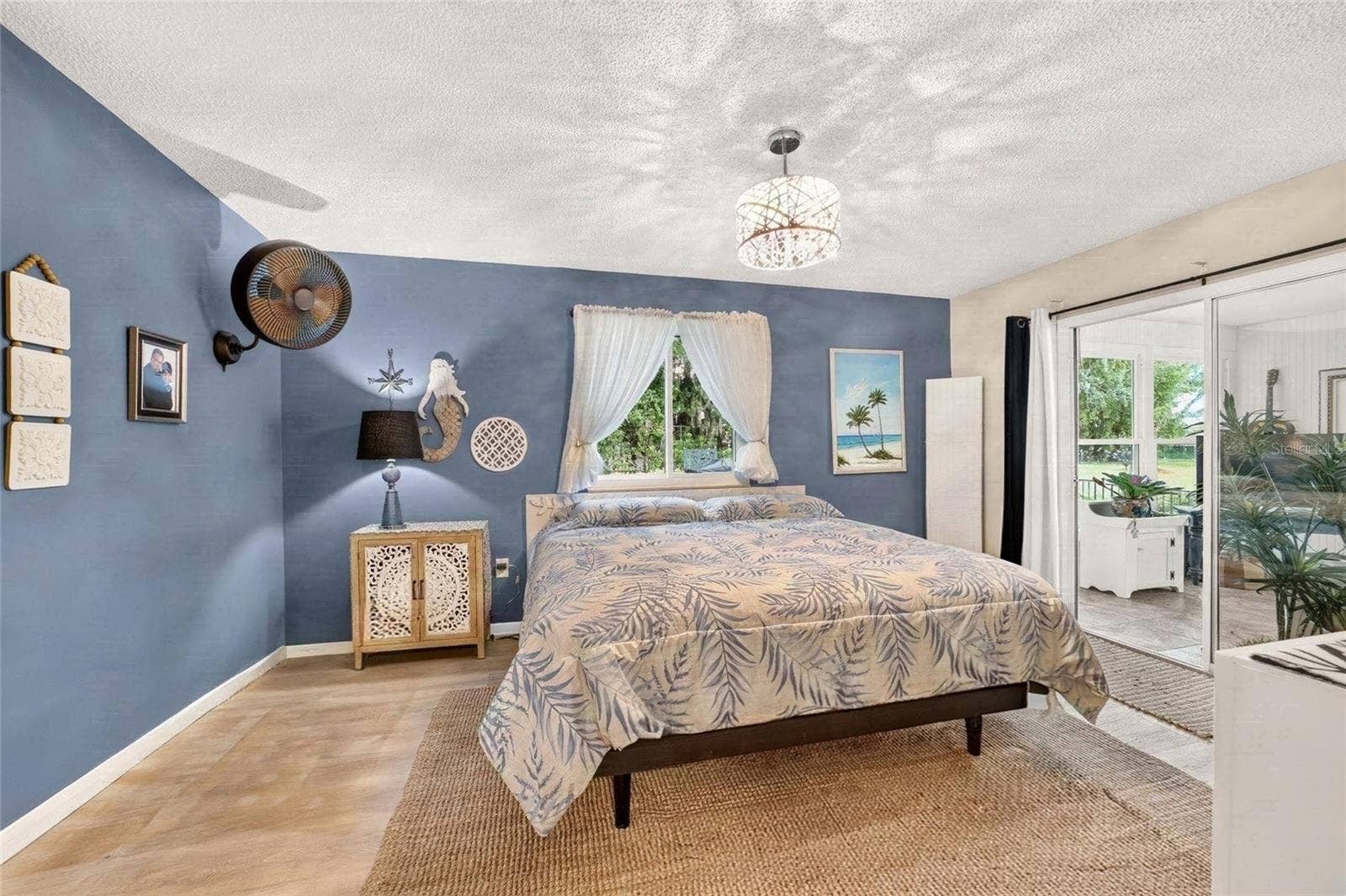 9282 SW 109TH LANE, Ocala, FL 34481 Primary Bedroom with direct access to the Florida room with sliders for light and curtains for privacy. Its the best of both worlds. Private Lot with lots of natural light. A pretty view from every room