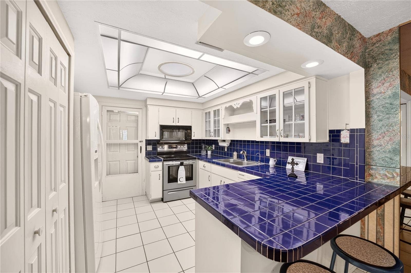 1708 NE 38TH AVENUE, Ocala, FL 34470 The kitchen is spacious and has lovely cobalt blue tiled countertops.