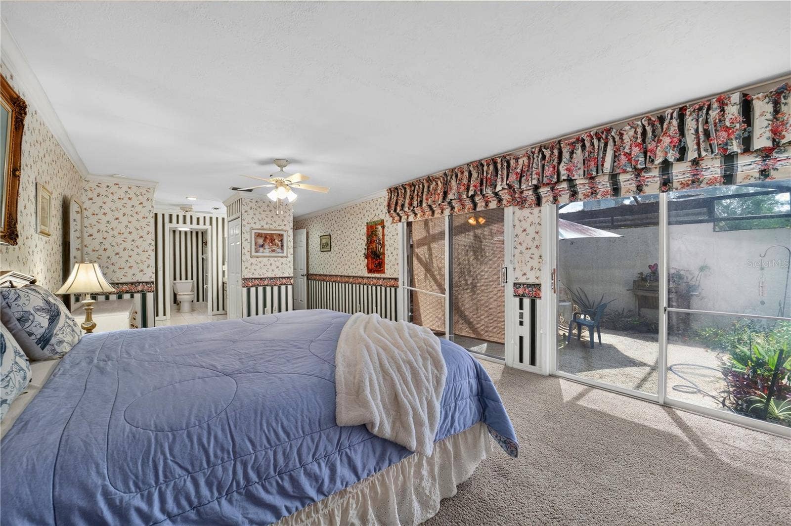 1708 NE 38TH AVENUE, Ocala, FL 34470 The primary bedroom has access to the rear patio through the glass sliding doors.