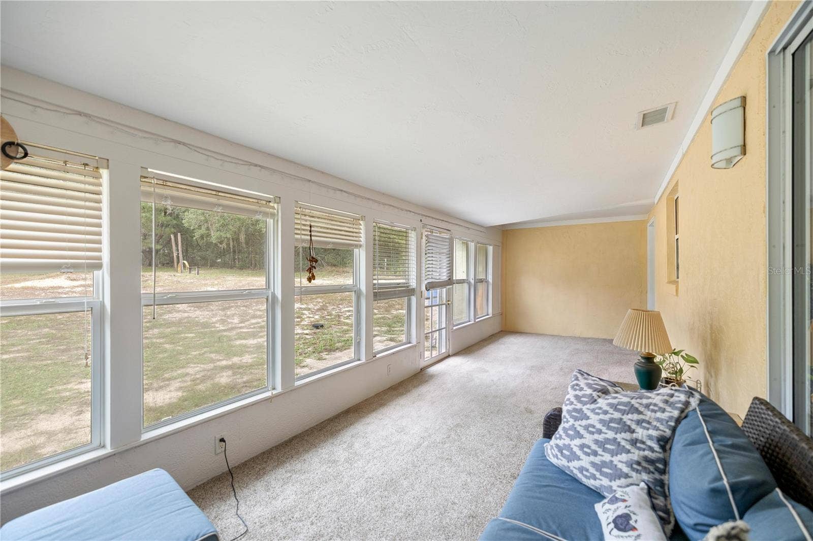 7910 SW 202ND COURT, Dunnellon, FL 34431 SUNROOM PREPPING STUFF TO MOVE & LOOKING PAST KITCHEN PASS-THRU WINDOW TO INSIDE LAUNDRY ROOM DOOR