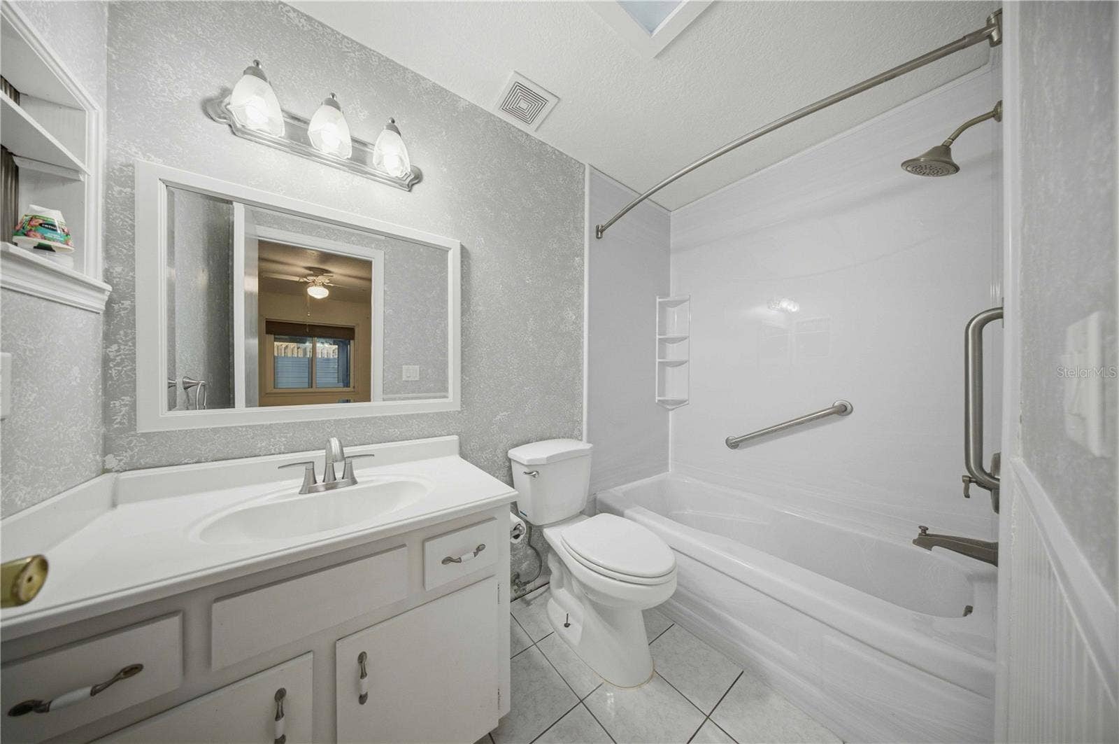 Primary en-suite, with wainscotting, comfort height toilet, and tub/shower combo with grab bars