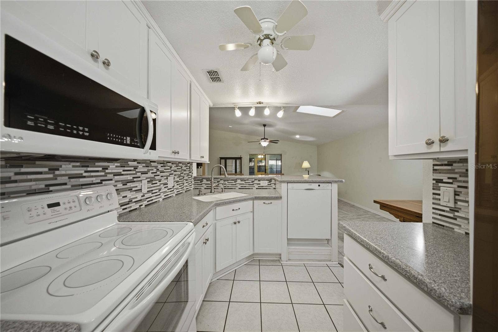 View from back of kitchen overlooking the great room, breakfast bar, and dinning area