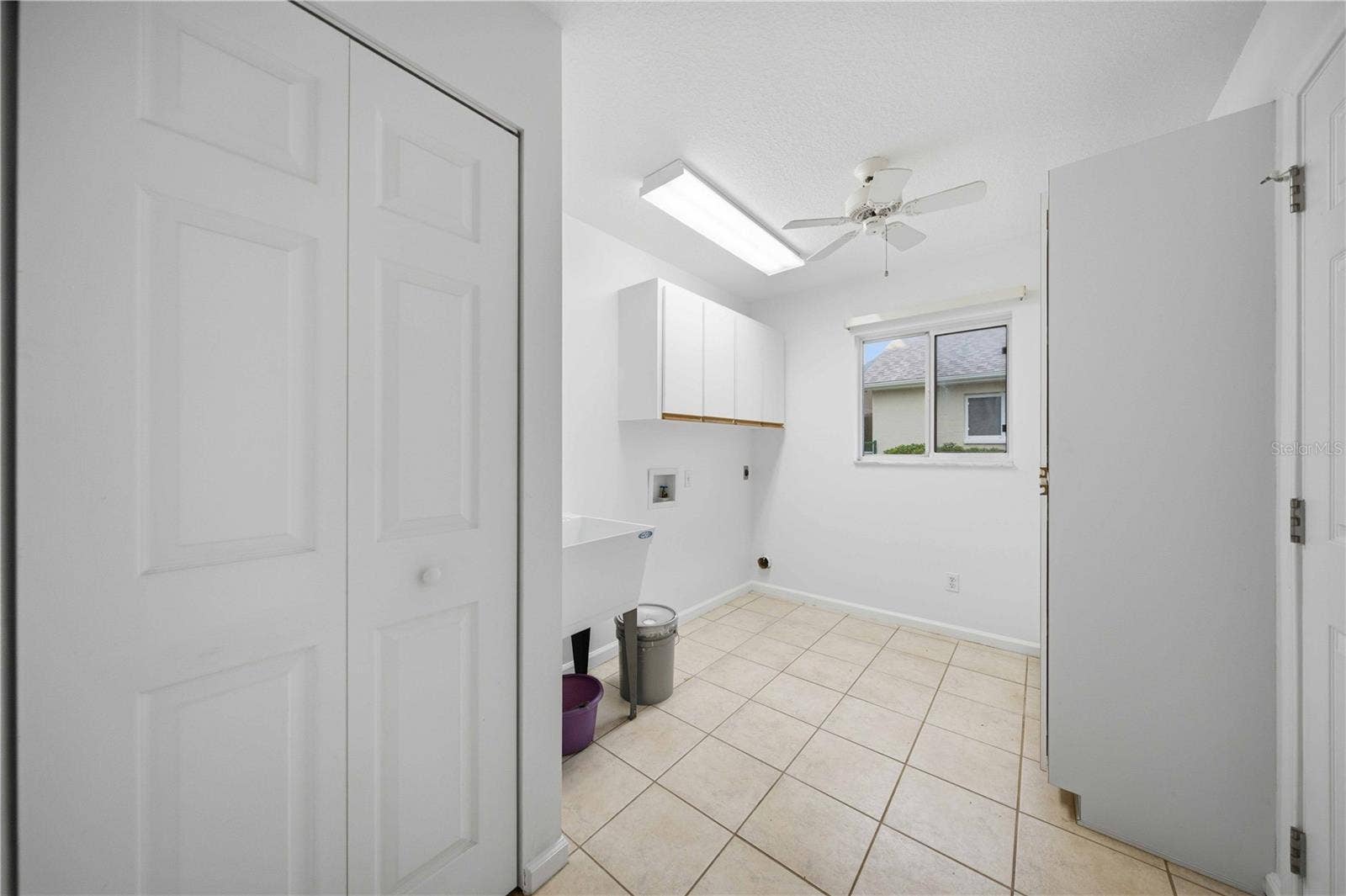 5126 NW 21ST LOOP, Ocala, FL 34482 Inside laundry with laundry tub and storage cabinets