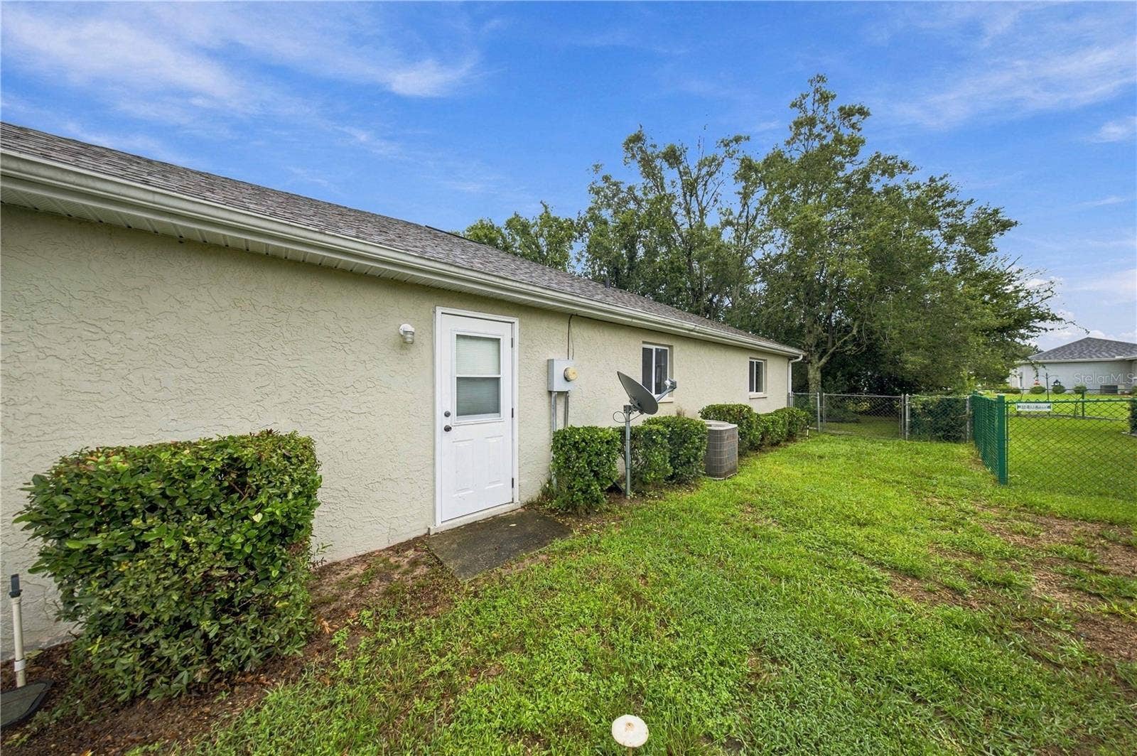 5126 NW 21ST LOOP, Ocala, FL 34482 Side yard. Door to garage
