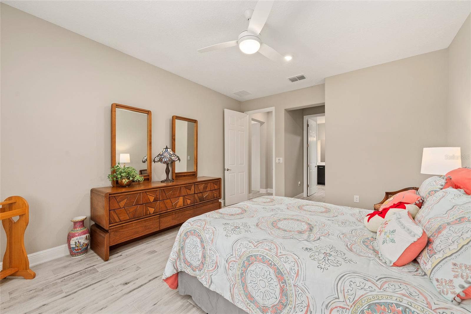 Another view of the spacious second primary suite, highlighting a convenient alcove and direct access to the private ensuite bathroom, offering a comfortable and functional retreat.