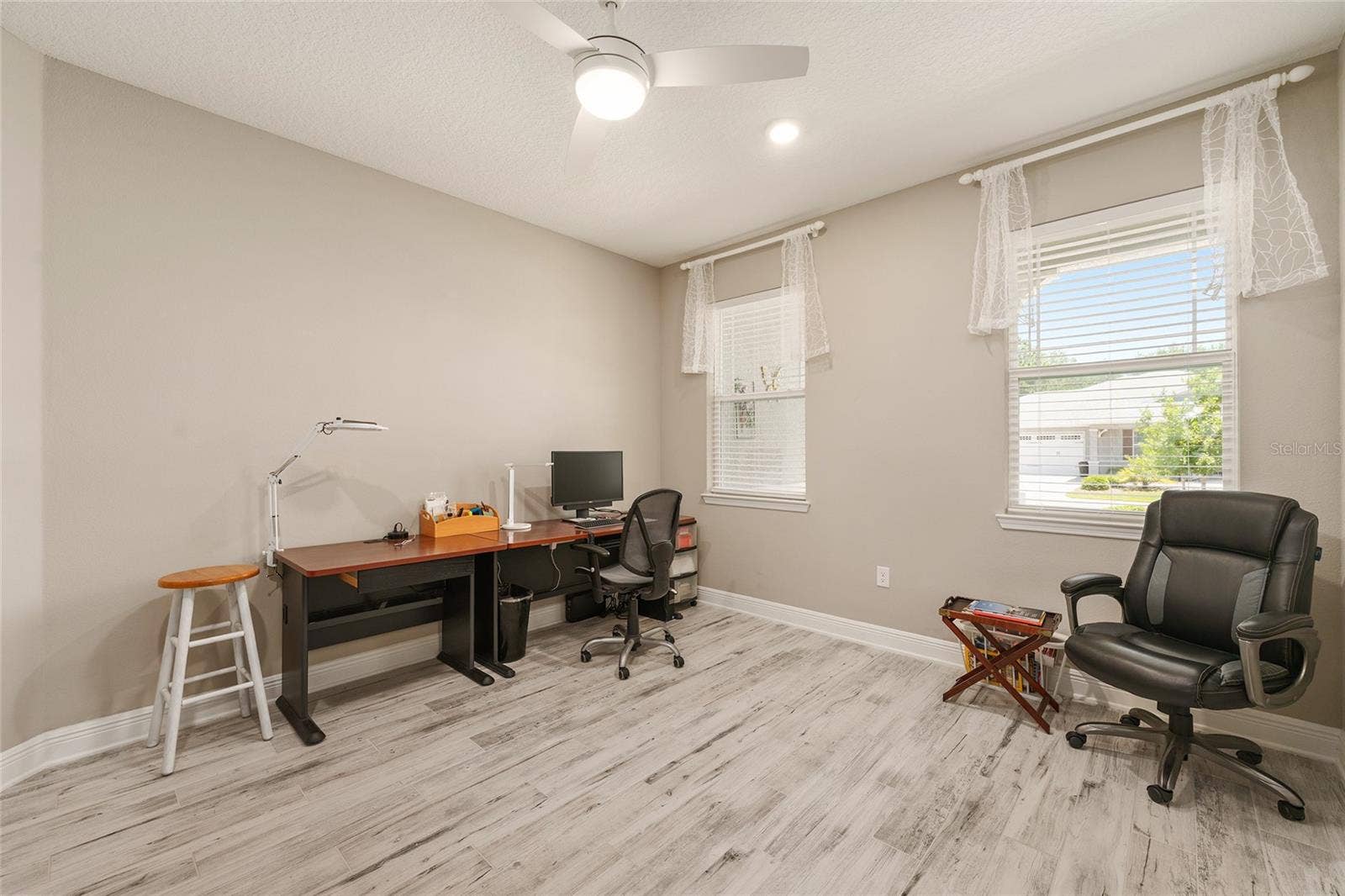 Two front-facing windows fill this spacious flex room with natural light, offering a bright and comfortable setting for a home office, reading lounge, or creative workspace.