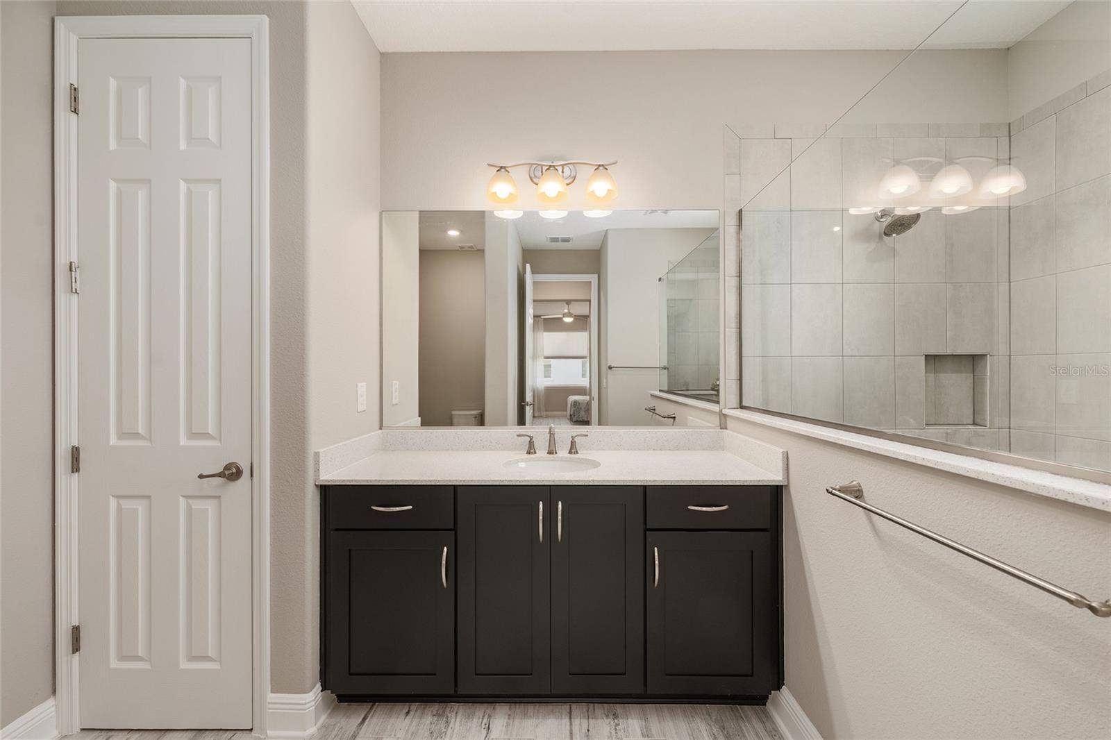 Second primary suite's private ensuite bathroom features a spacious vanity with a light-colored countertop, rich espresso cabinetry, generous storage, a large mirror, and a convenient linen closet.