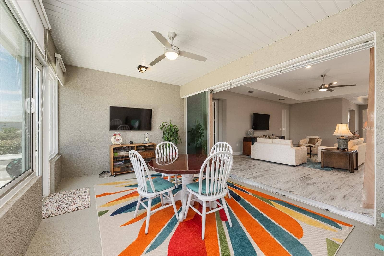 Enclosed lanai featuring expansive stacking sliding glass doors and a zero-entry transition from the great room, creating an effortless flow between the two living spacesperfect for entertaining and enjoying Florida living year-round.