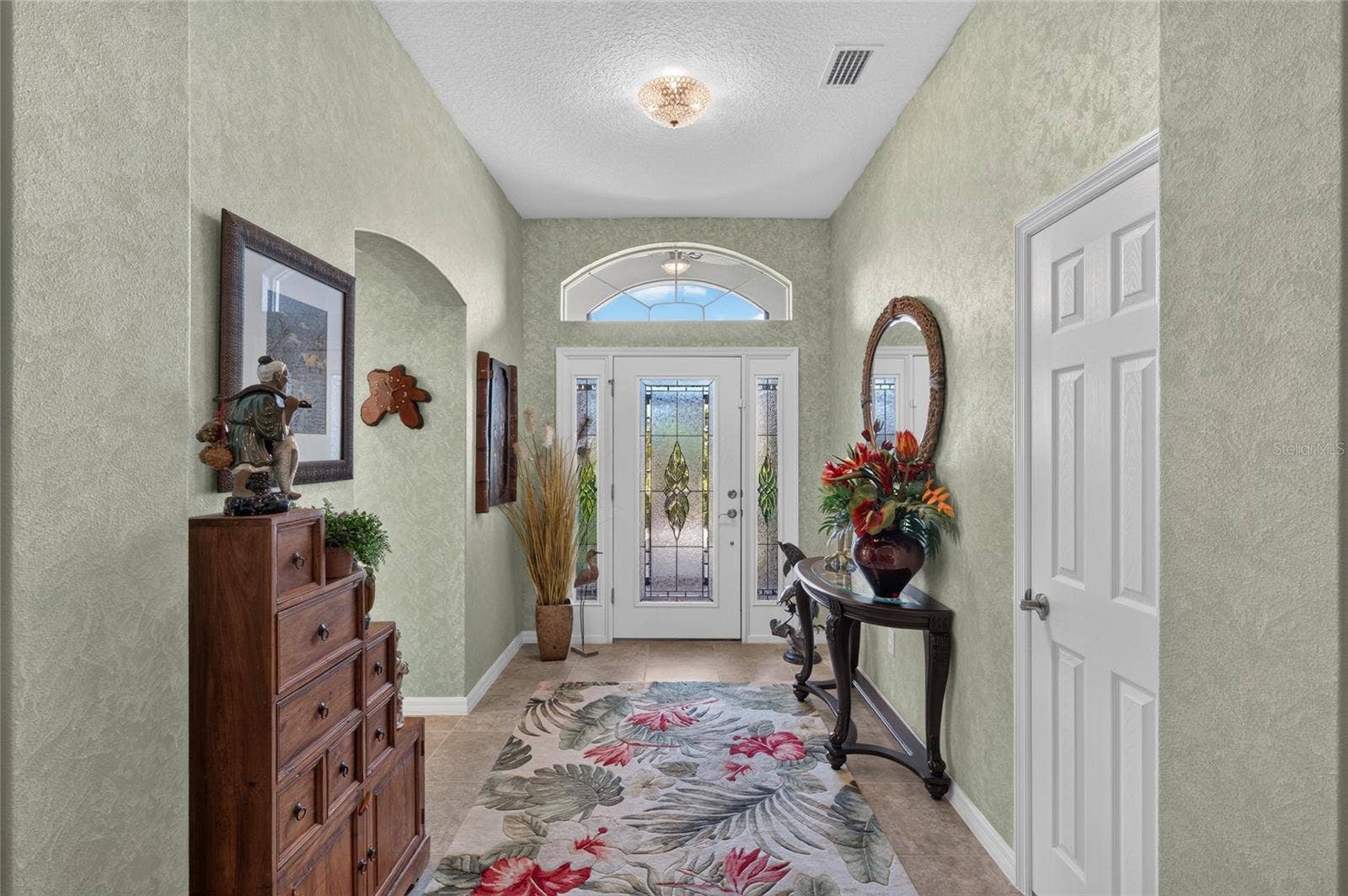 LEADED GLASS FRONT DOOR WITH DOUBLE SIDE LIGHTS AND TRANSOM WINDOWS.